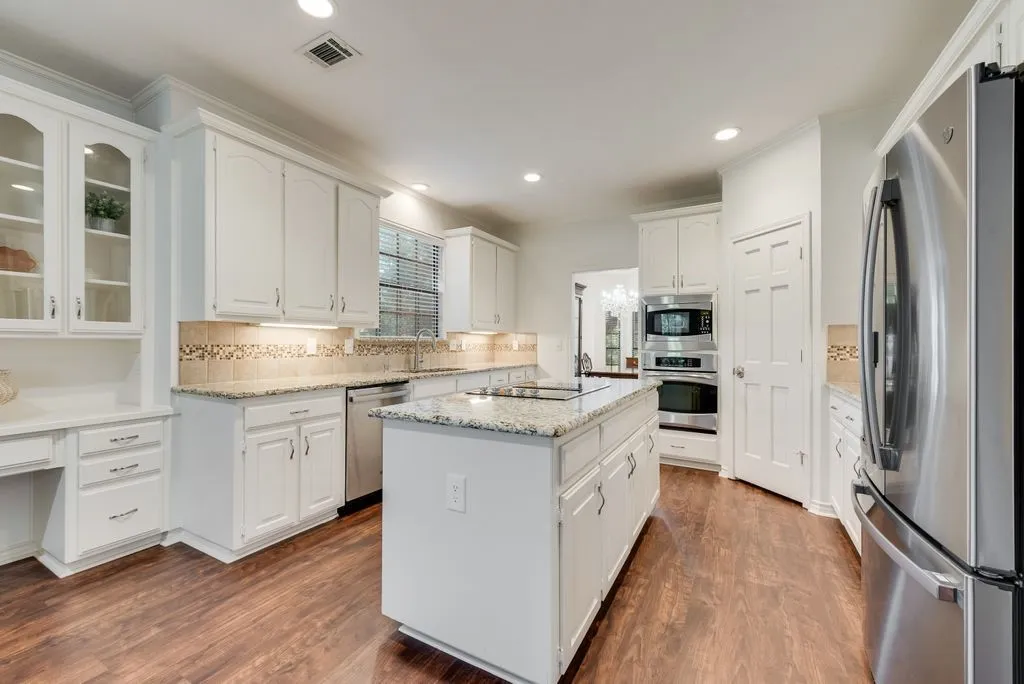 Spacious gourmet kitchen with island, desk, hutch and buffet, stainless appliances.
