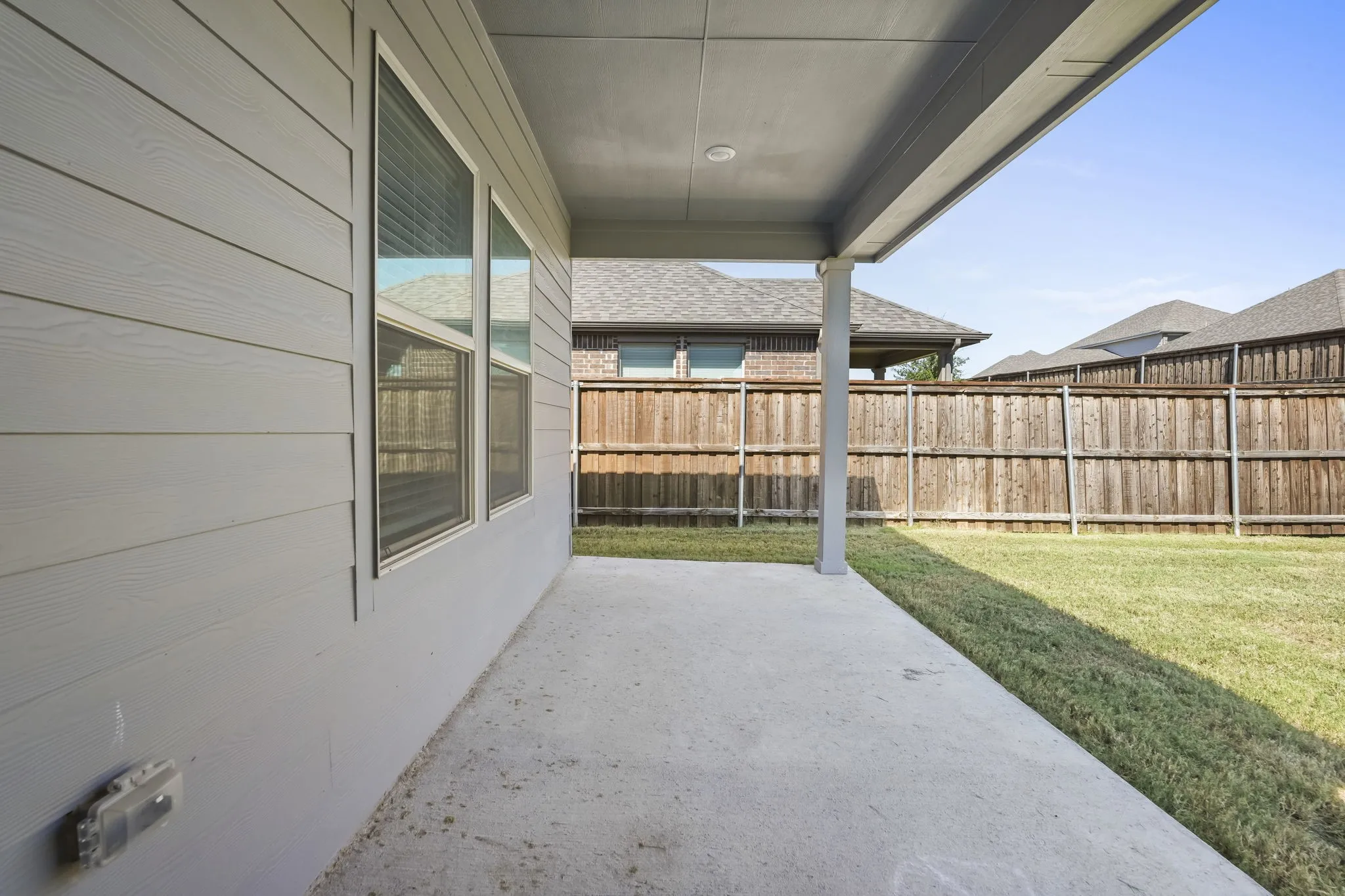 Covered patio with a concrete surface, siding exterior, and a privacy fence