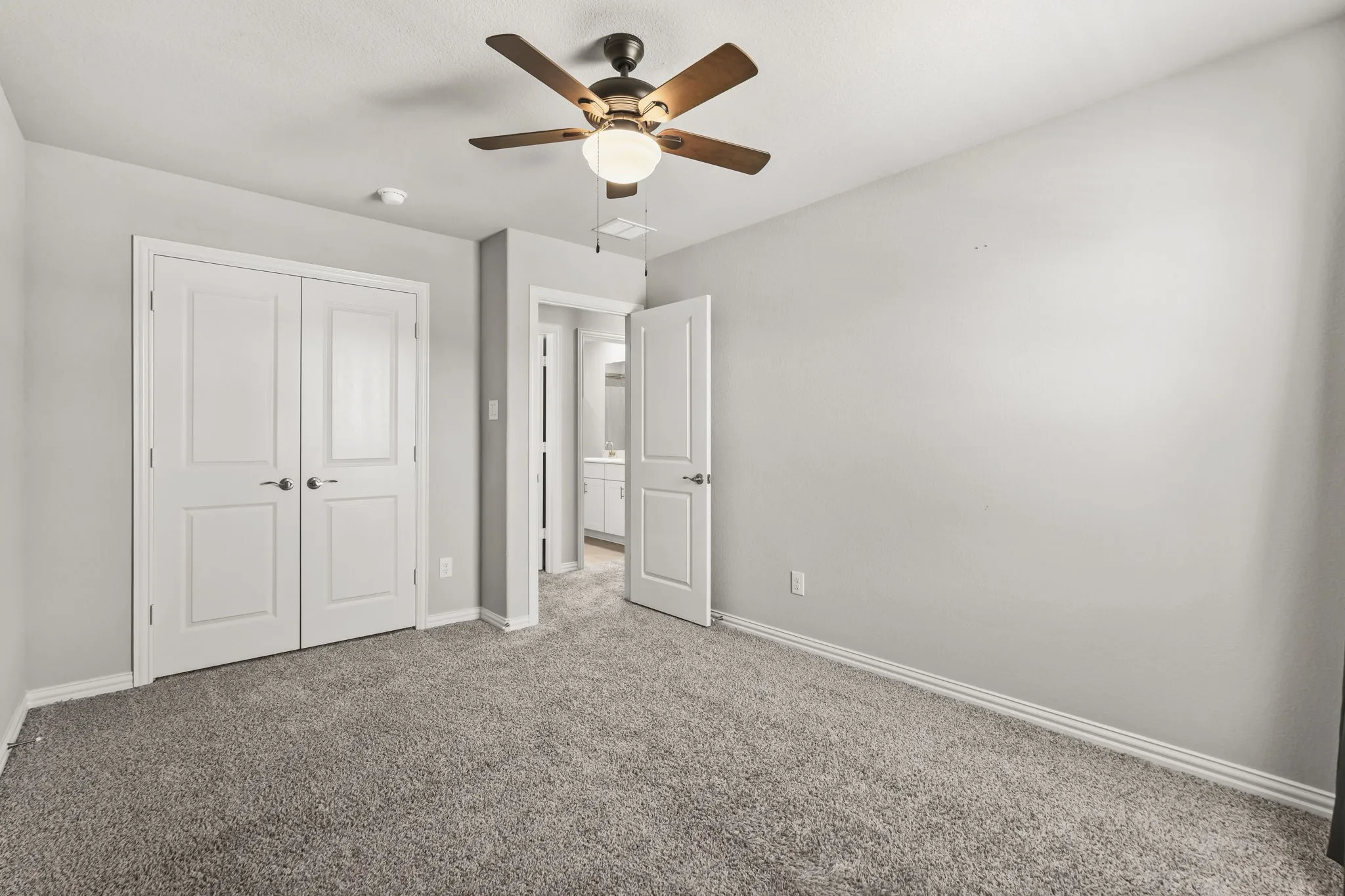 Plush carpet flooring, ceiling fan with integrated lighting, double-door closet, and neutral wall tones