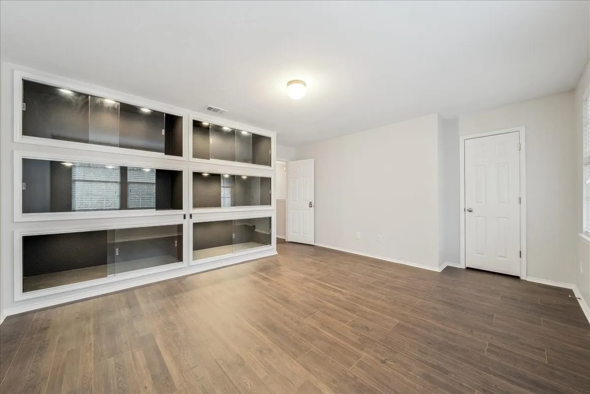 Built-in display cabinetry with sliding glass doors and integrated lighting