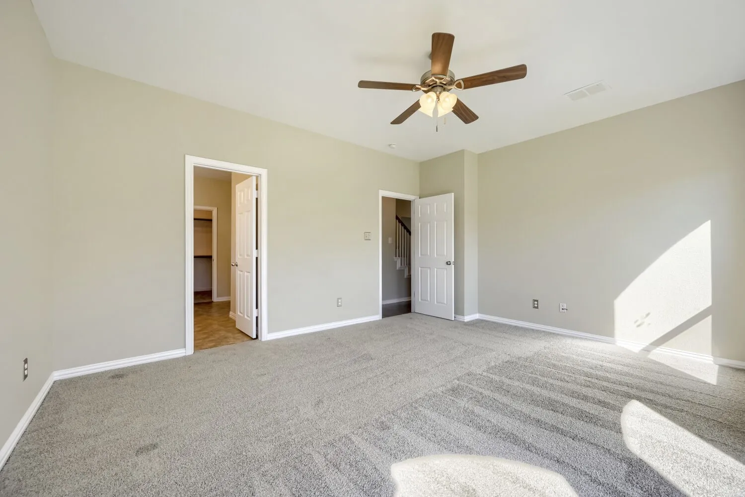 Carpeted flooring, neutral wall tones, ceiling fan with integrated lighting, white trim, and white paneled doors