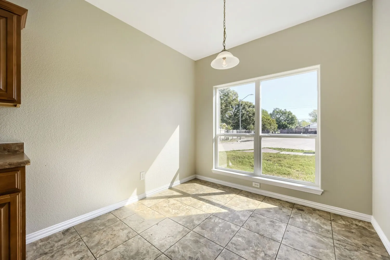 Tile flooring, recessed lighting, built-in cabinetry, and a large window