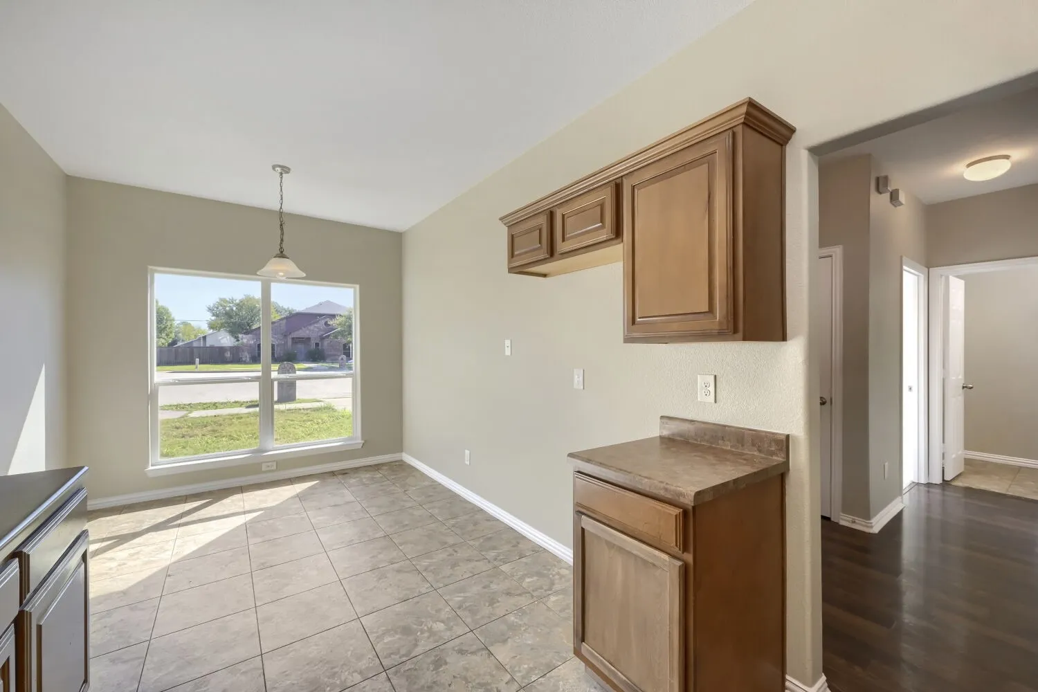 Tiled flooring, overhead lighting, wood-finish cabinetry, and a large​​‌​​​​‌​​‌‌​‌‌​​​‌‌​‌​‌​‌​​​‌​​ window