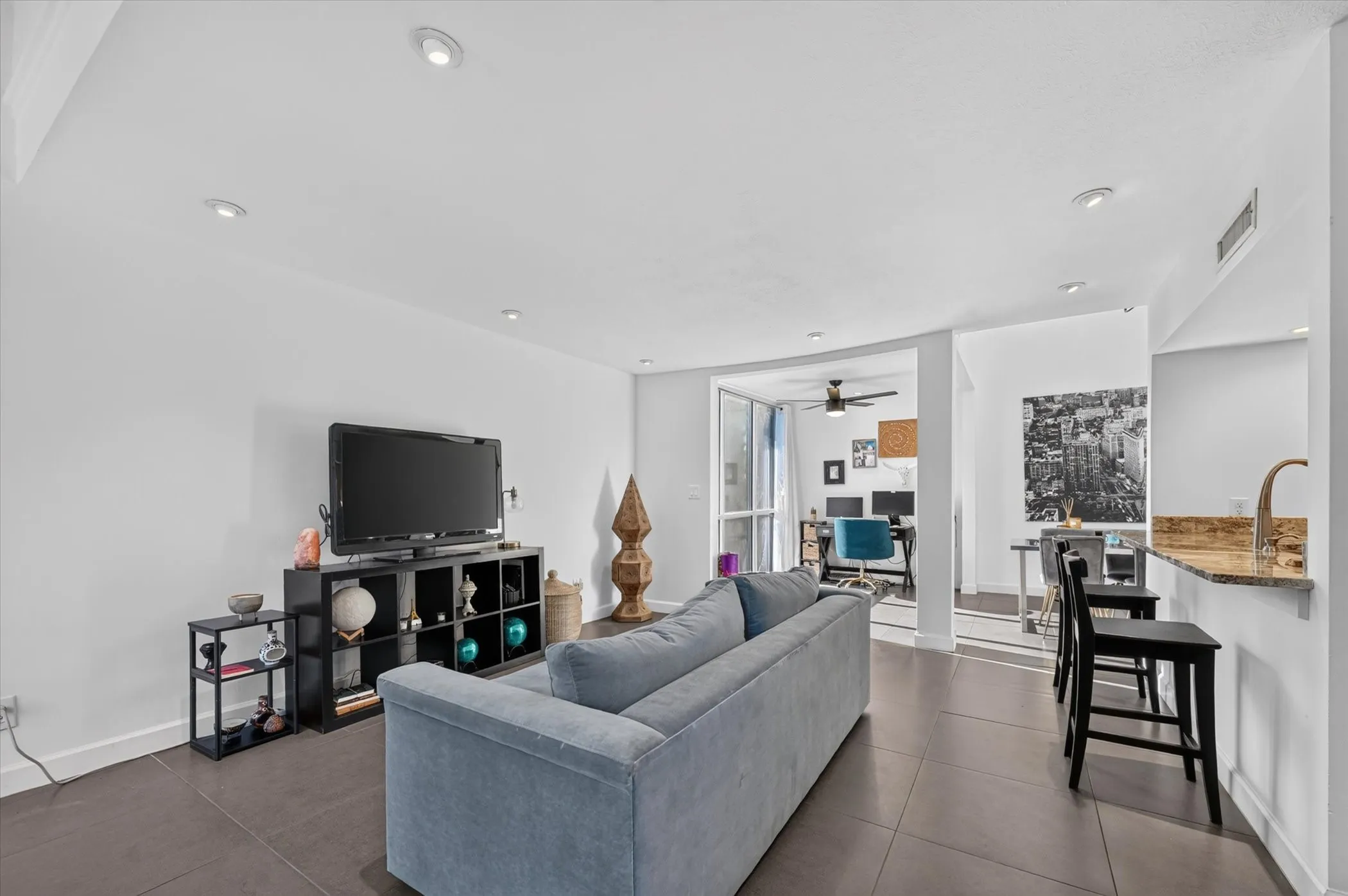 Recessed lighting, tile flooring, and a breakfast bar with a stone-finish countertop