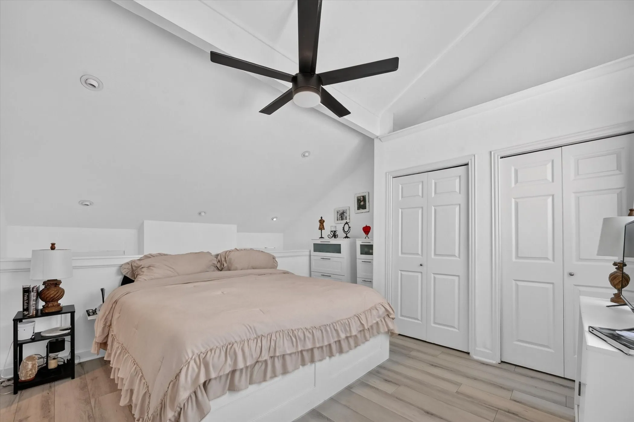 Vaulted ceilings with exposed beams, recessed lighting, wood-finish flooring, and two paneled closet doors