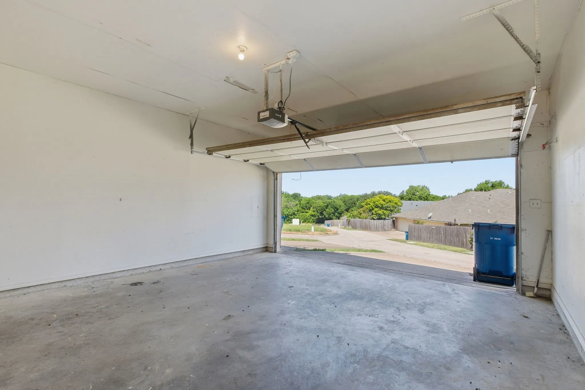 Attached garage with a concrete floor and an automatic overhead door opener