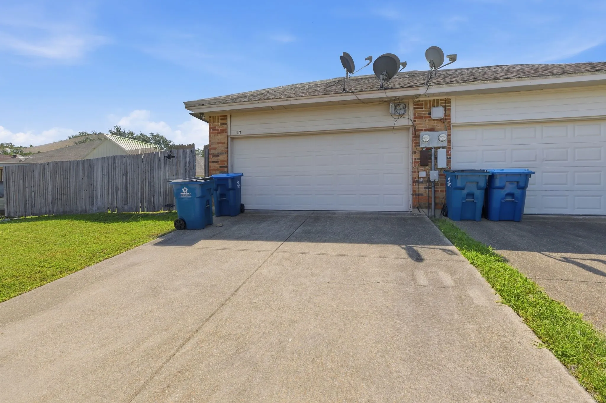 Attached garage with white door and brick accent column