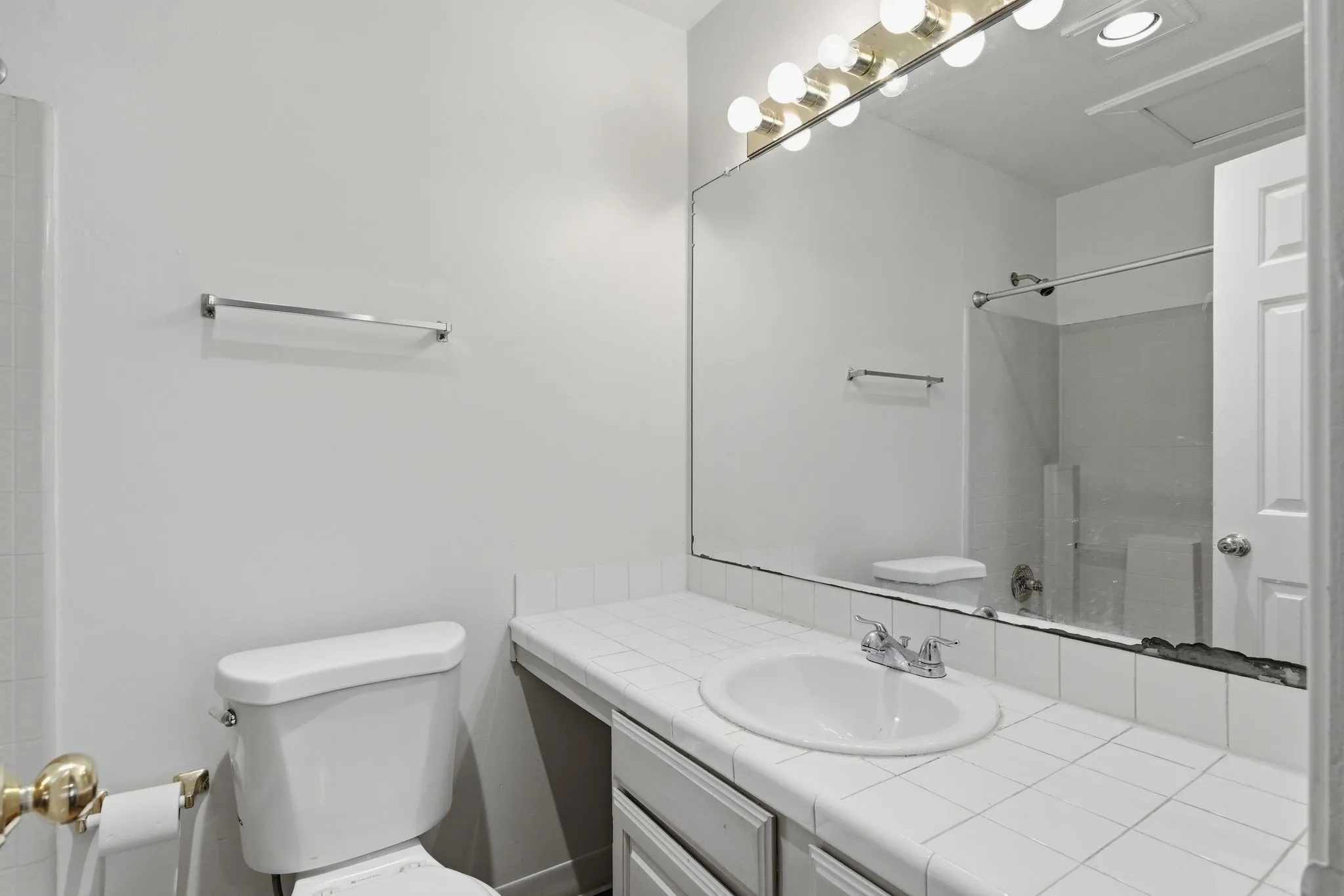 Integrated vanity with a white tile countertop, drop-in sink, and chrome-finish faucet
