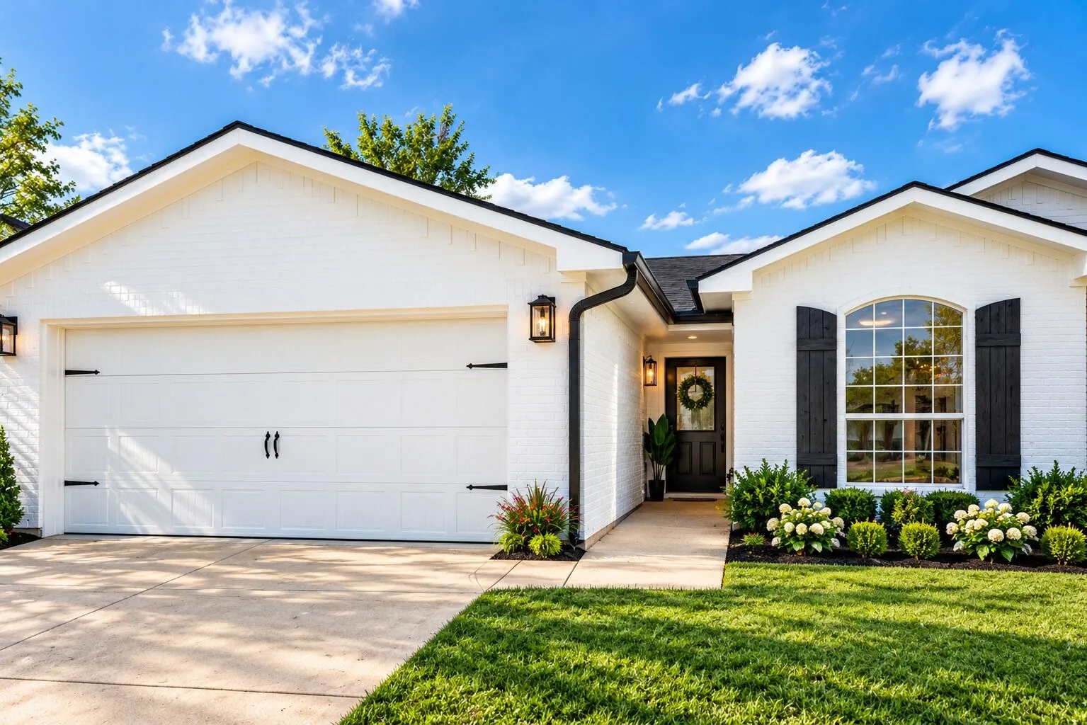 White brick exterior with black shutters, arched window with divided lites, attached garage, and a manicured lawn
