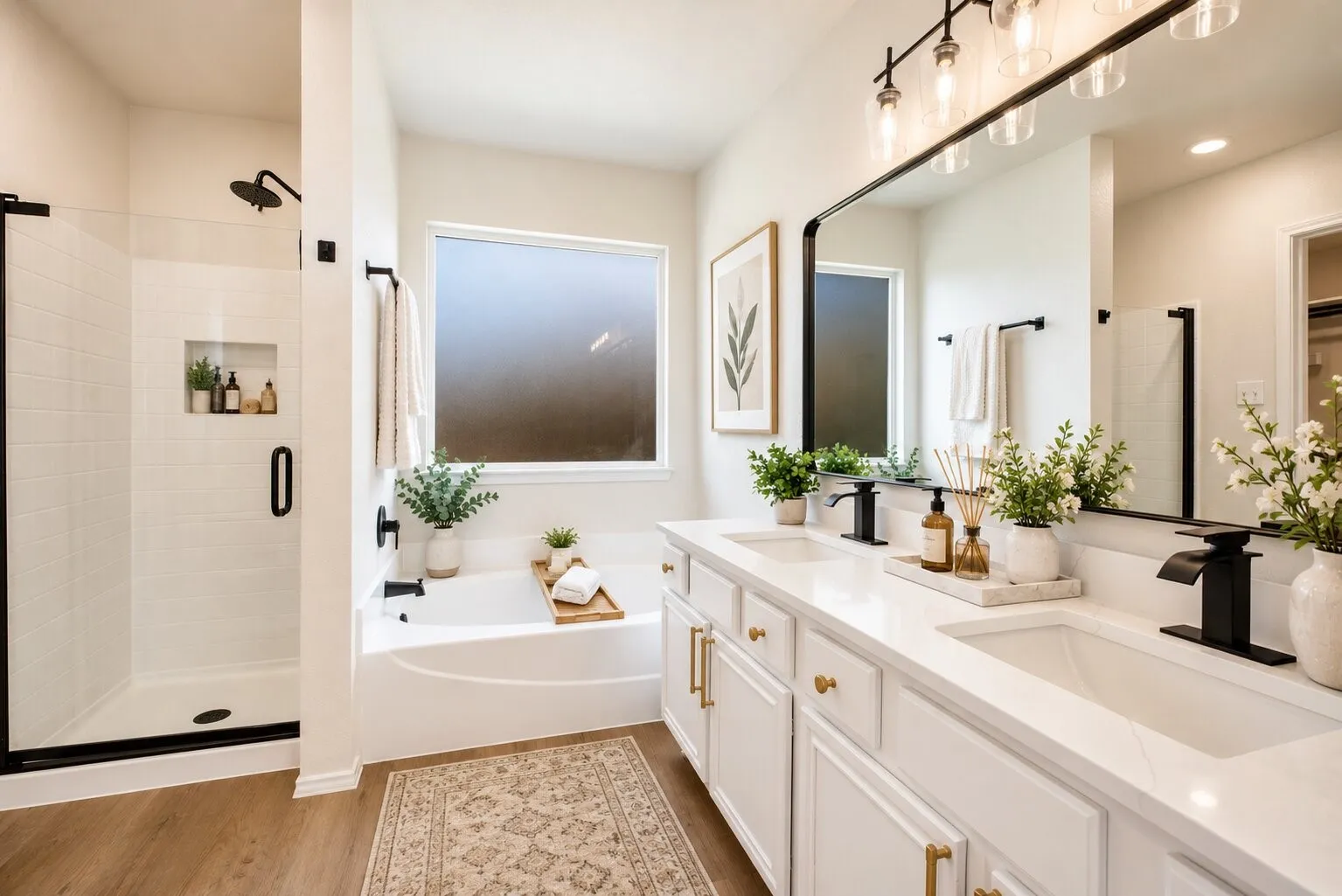 Dual vanity with undermount sinks and quartz countertops, wood-finish flooring, built-in soaking tub, walk-in shower with tile surround and glass enclosure, and modern black fixtures
