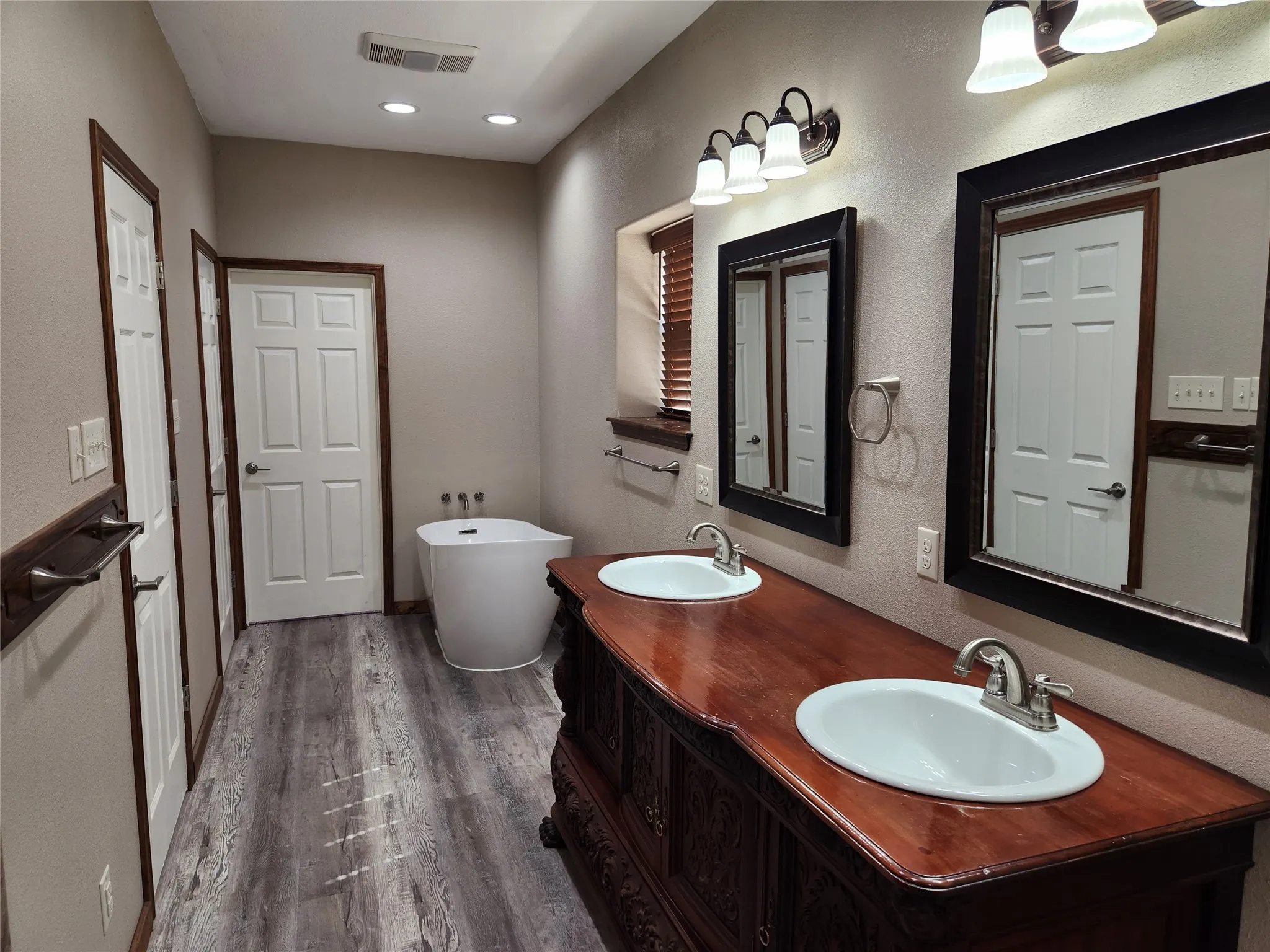 Primary bathroom with soaking tub and custom dual vanity.