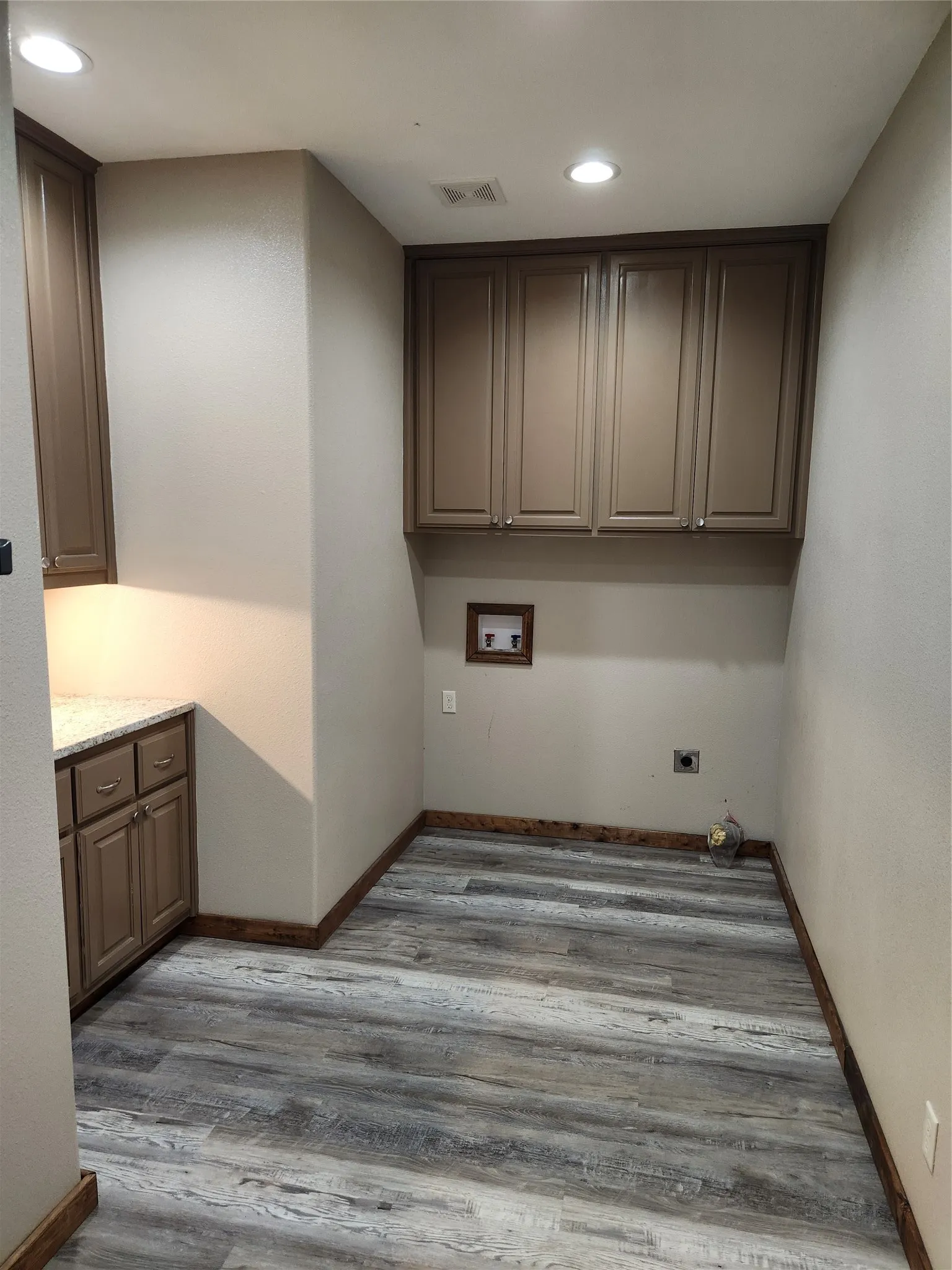 Laundry room with full-sized washer and dryer hookups and workspace.