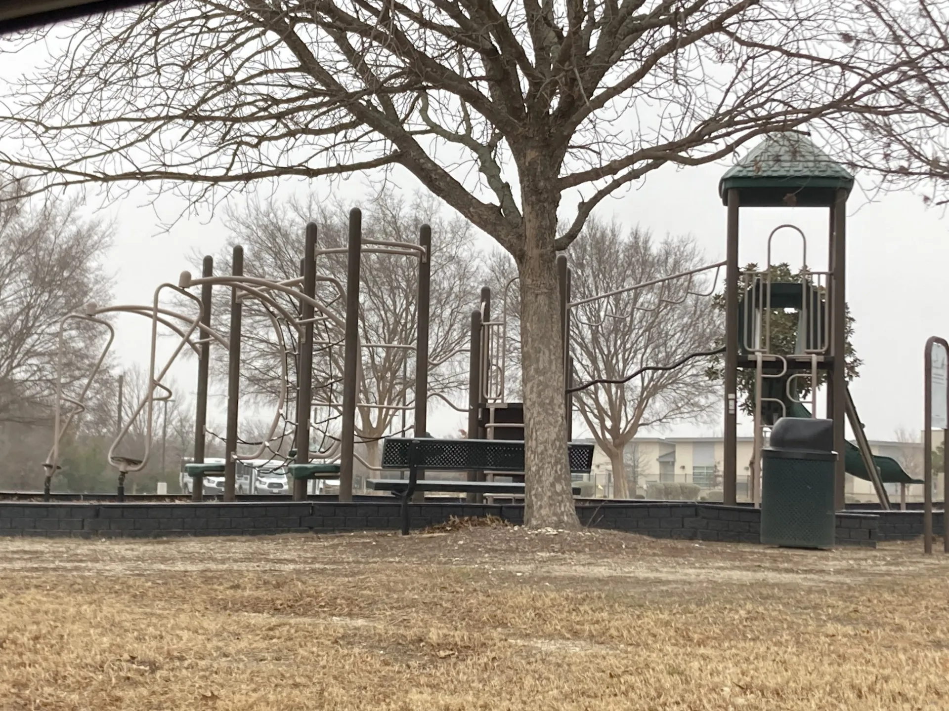 Community playground featuring a climbing structure, slides, and monkey bars