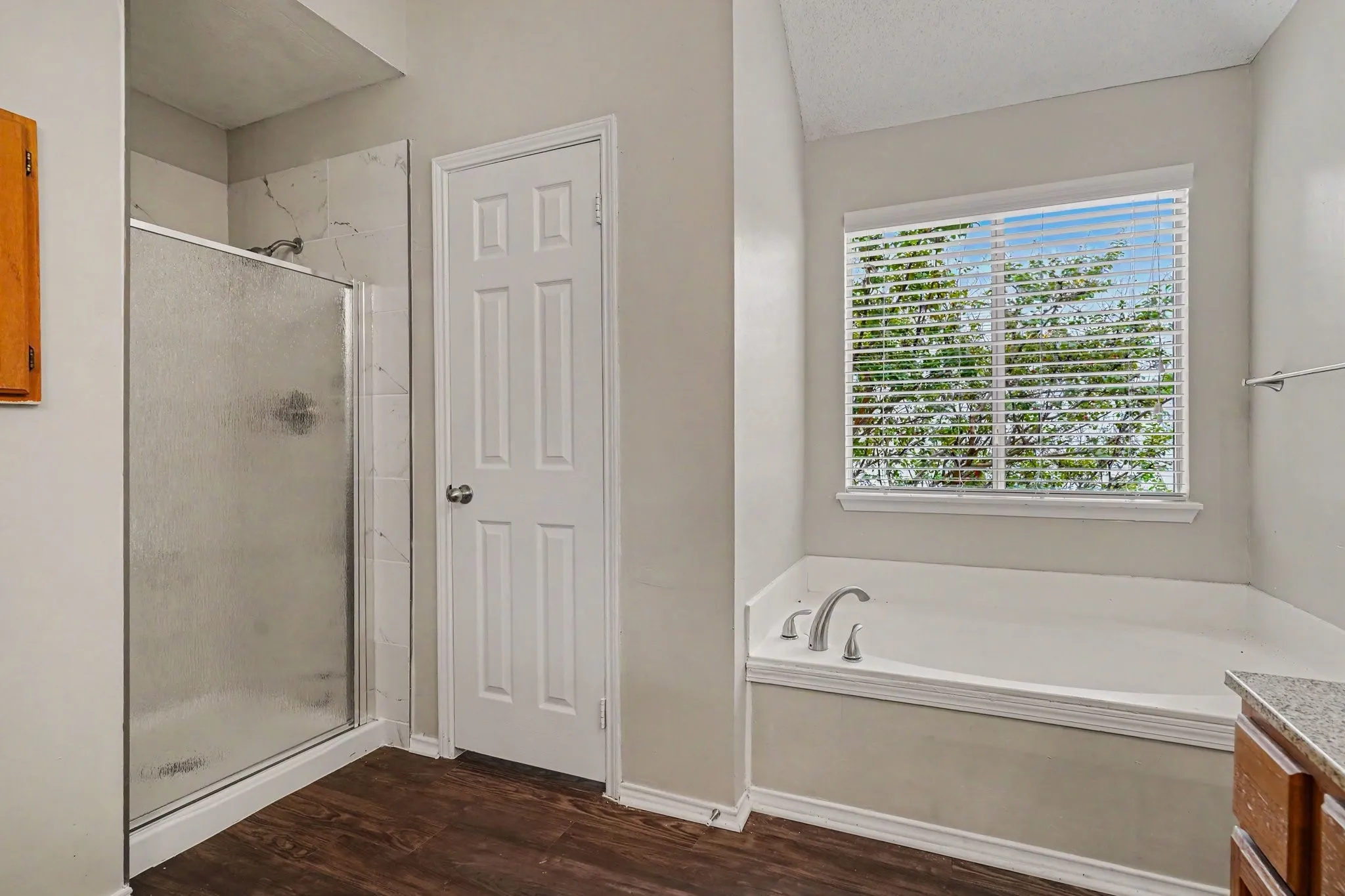 Primary bathroom offers separate garden tub and shower