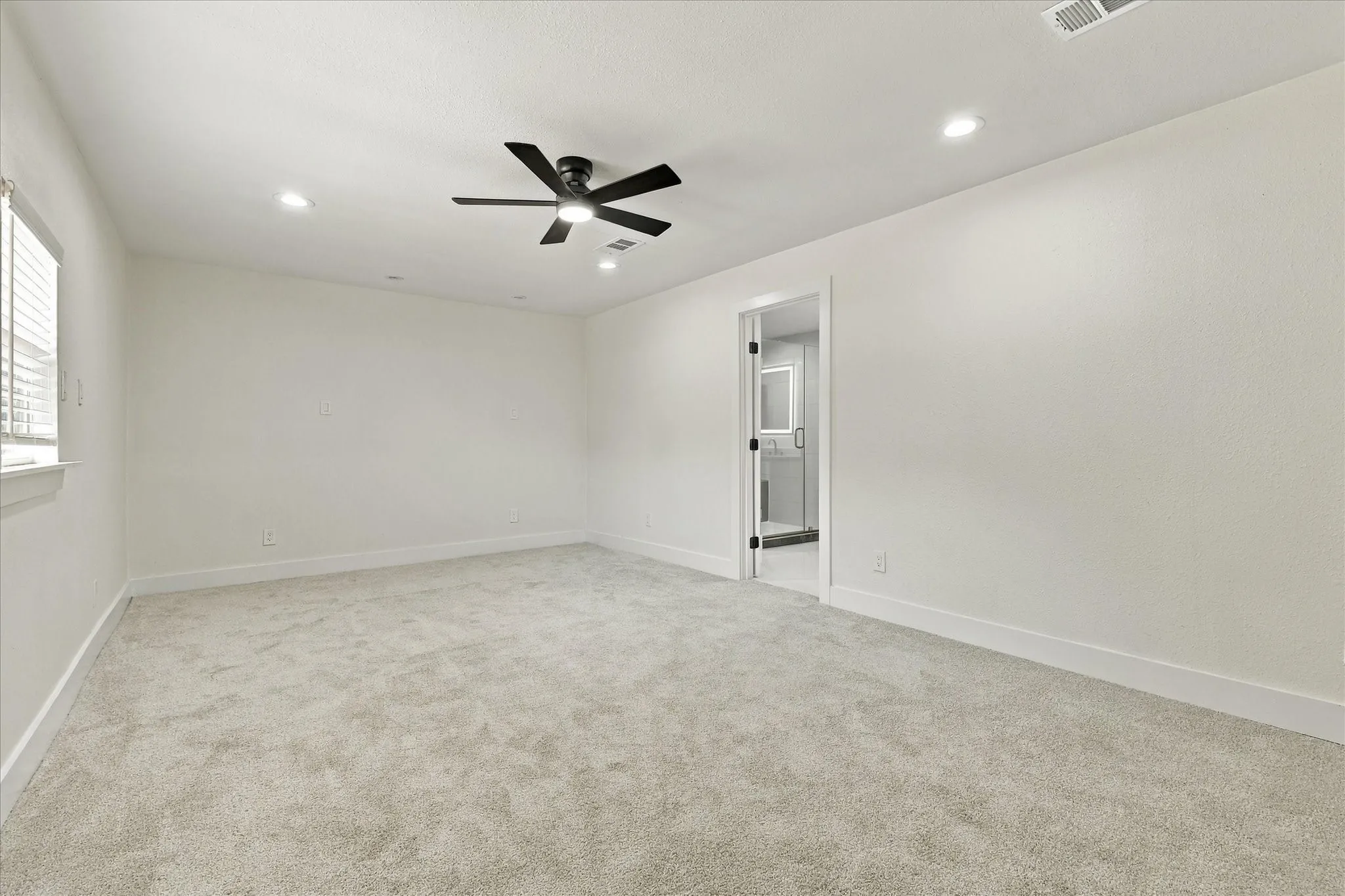 Recessed lighting, ceiling fan, and light gray carpeting