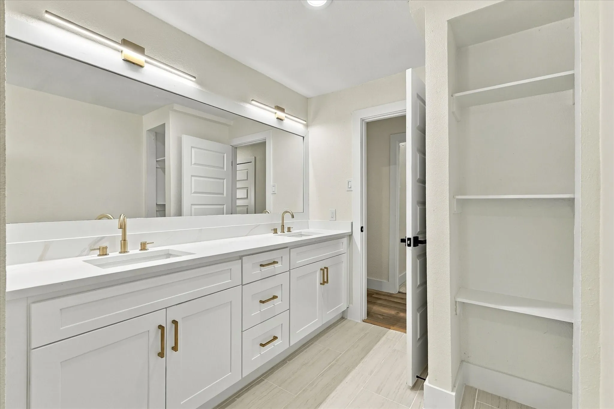 Bathtub with a dark-toned stone-look tiled surround, integrated shower niche, and a contrasting light-toned tiled wall