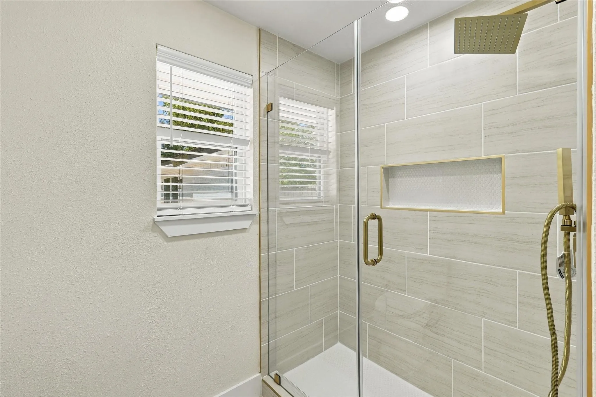 White vanity with shaker-style cabinetry, a white countertop featuring subtle veining, and a black-finish faucet