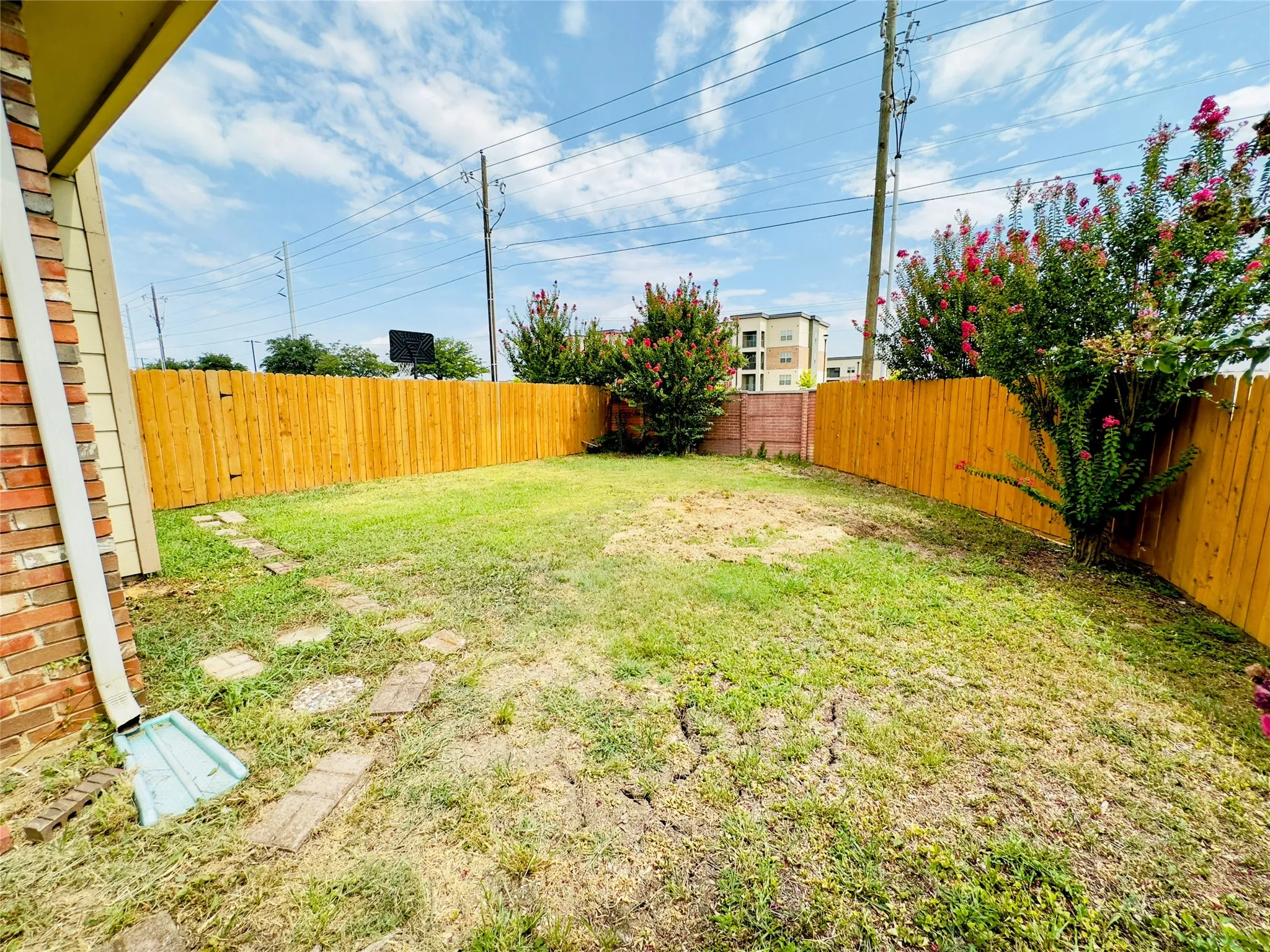 Enclosed yard featuring a wooden fence and existing landscaping