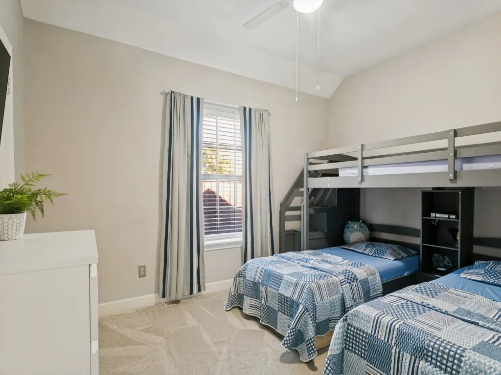 Vaulted ceiling, ceiling fan, window with blinds, light gray wall paint, and gray carpet flooring