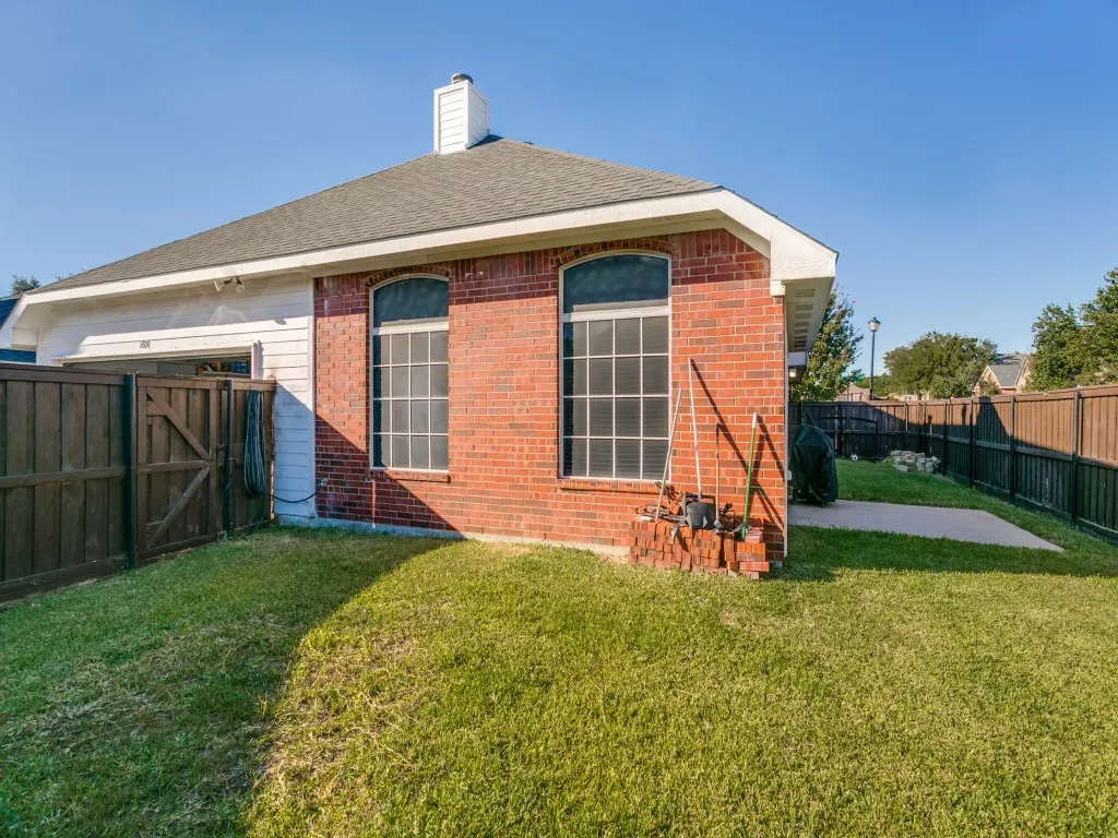 Red brick exterior with arched windows, shingle roof, and a white chimney