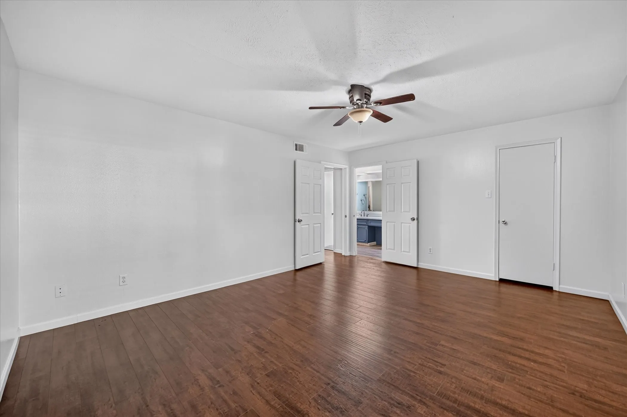 vinyl plank wood like finish flooring, white walls, and a ceiling fan with integrated lighting