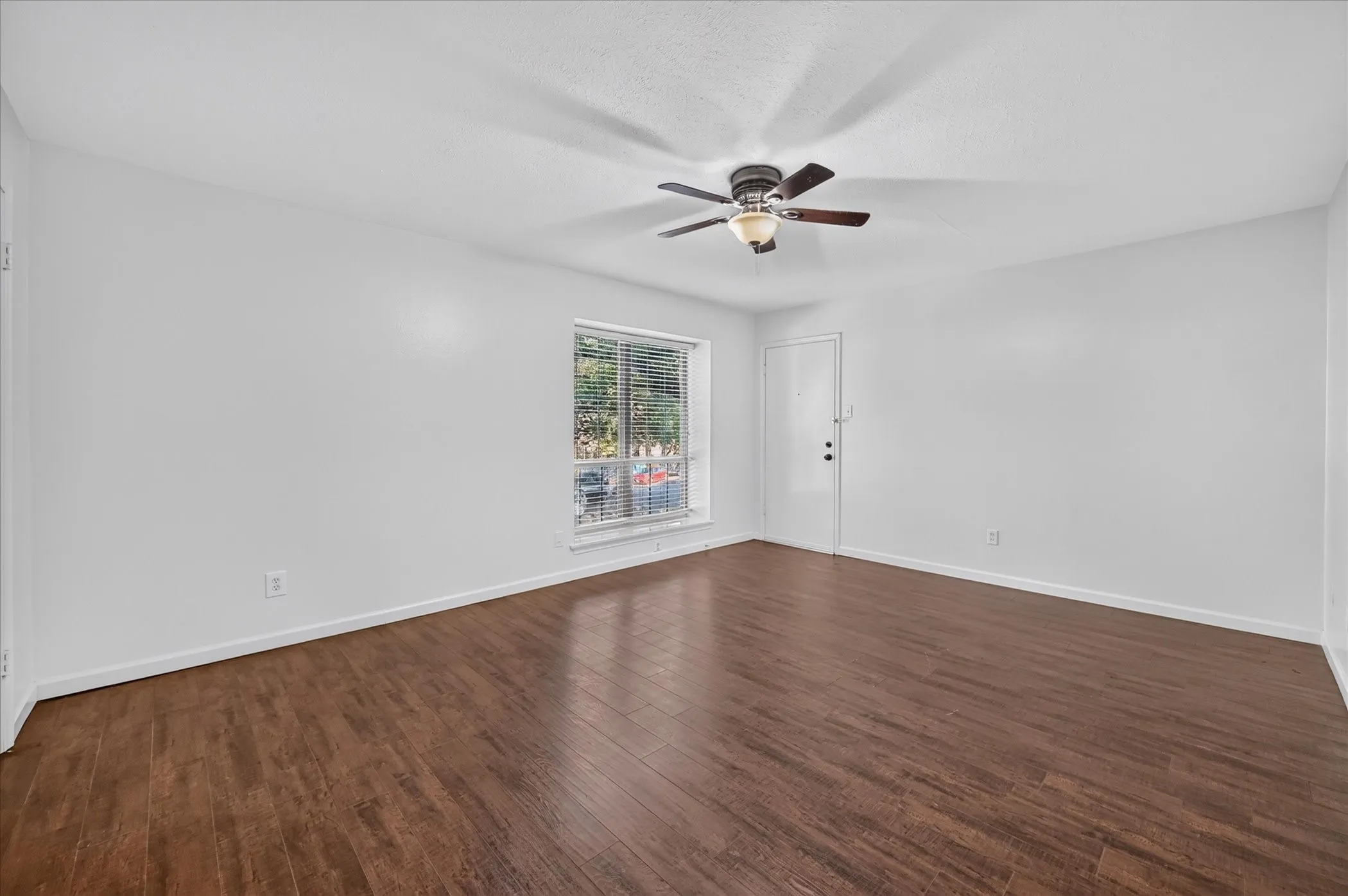 vinyl plank wood like finish flooring, white walls, and a ceiling fan with integrated lighting