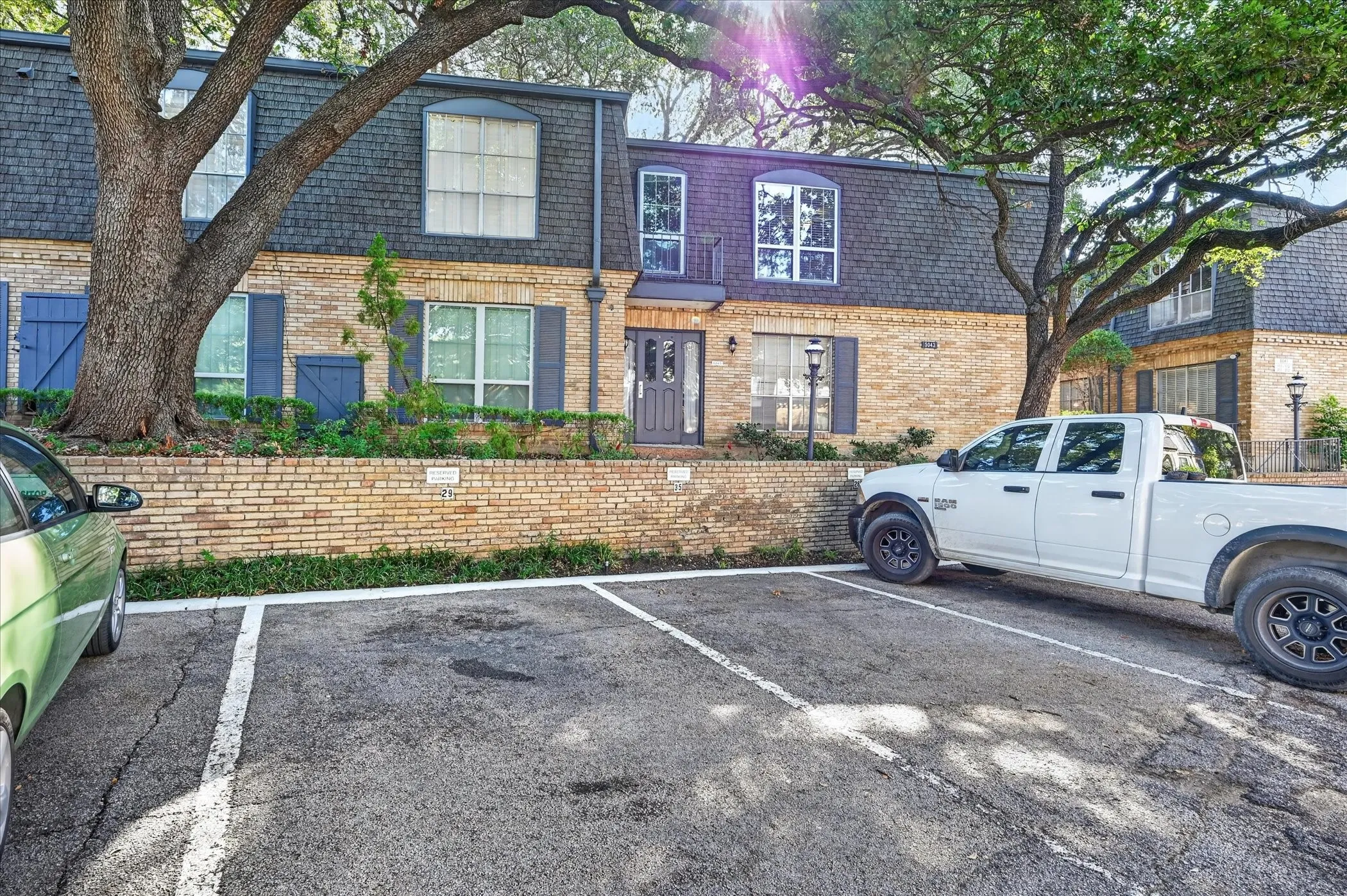 Brick facade with a mansard roof, dormer windows, and exterior shutters
