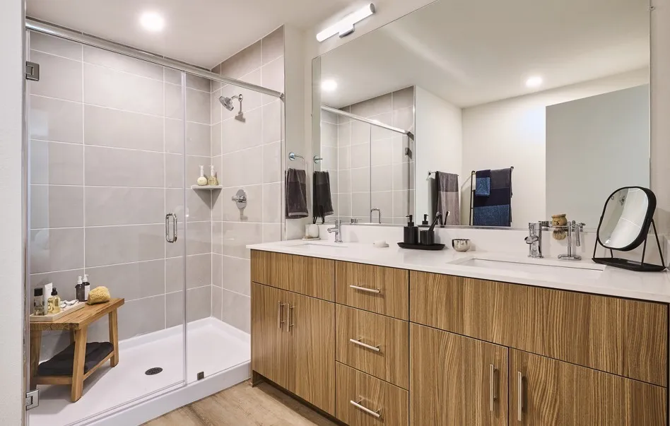 Full bathroom with a shower stall, double vanity, and recessed lighting