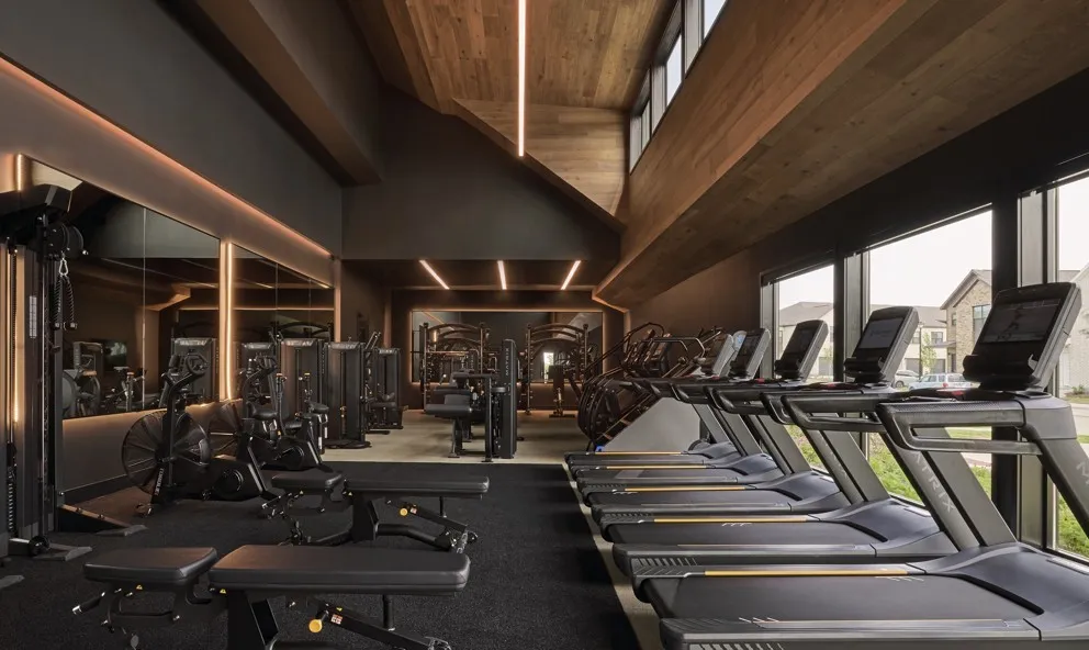 Gym with plenty of natural light, a towering ceiling, and wooden ceiling
