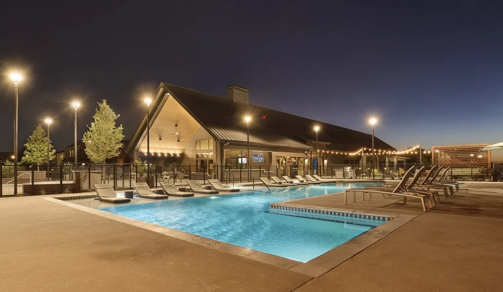 Pool at twilight featuring a patio and a community pool
