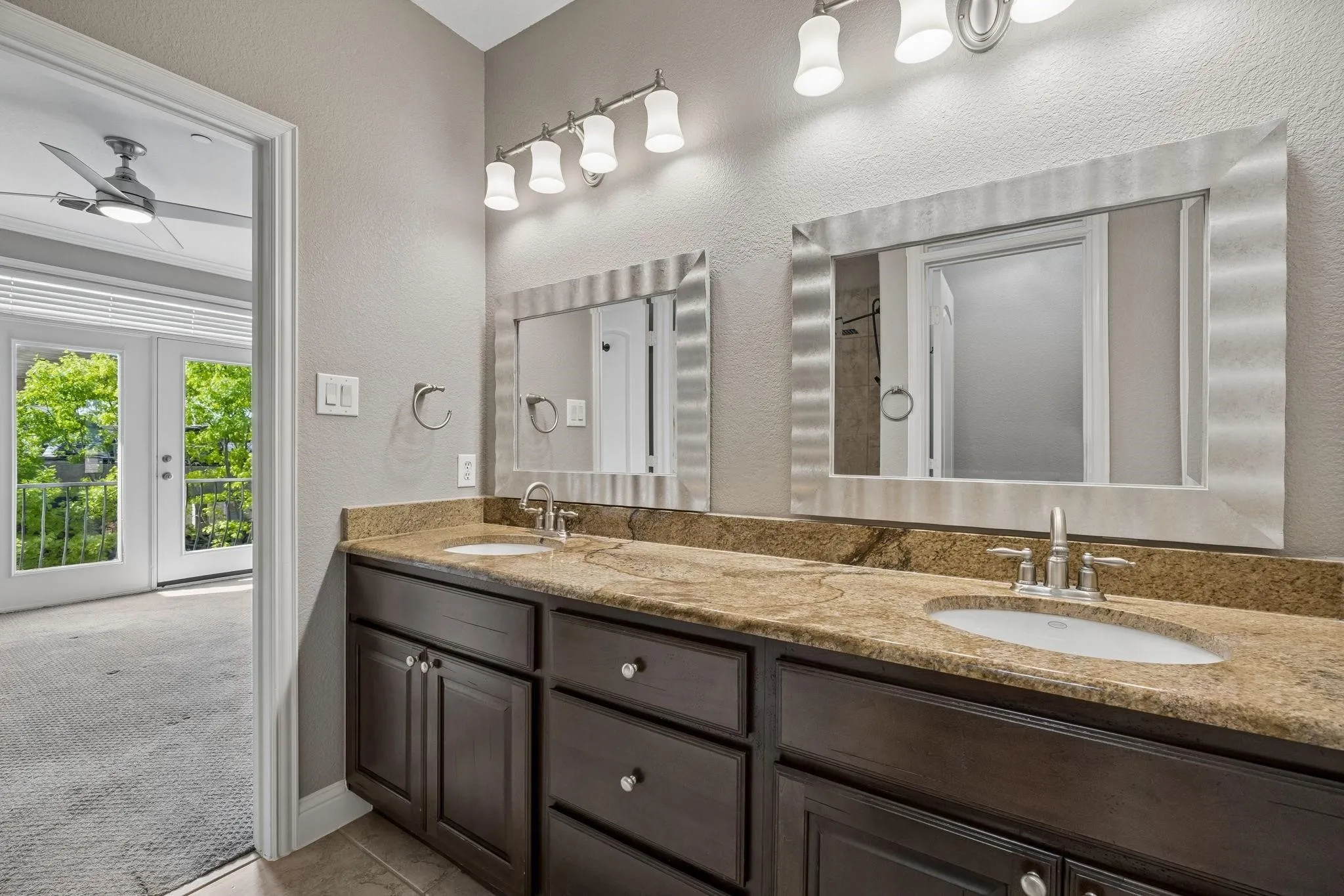 Dual vanity with stone countertop, undermount sinks, and dark wood-finish cabinetry