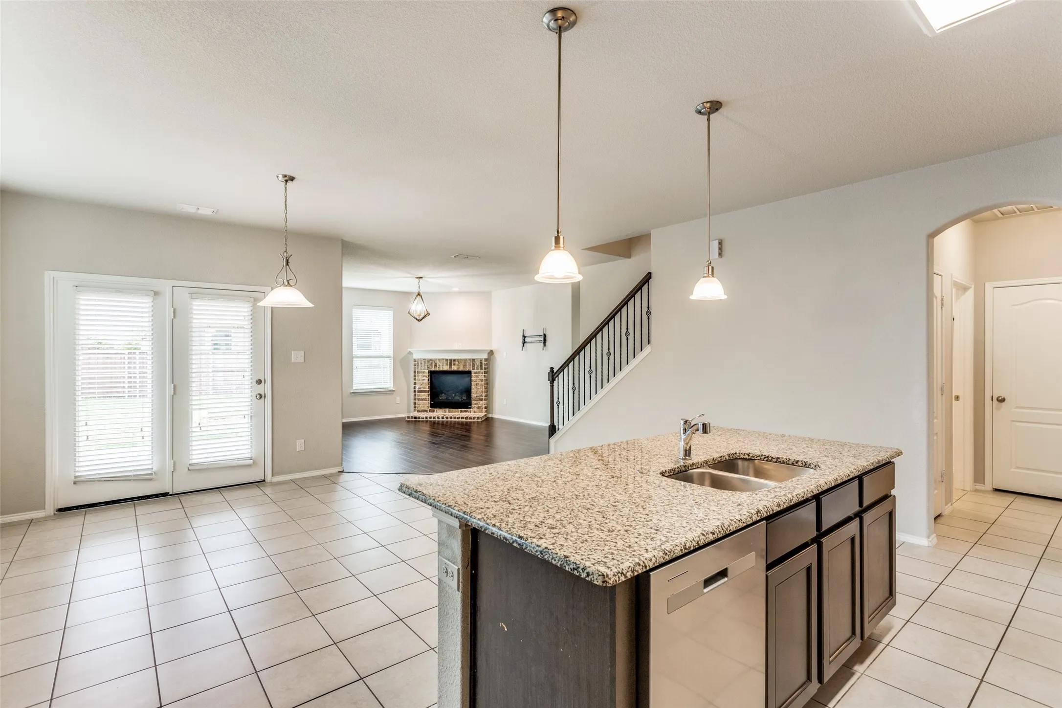 Kitchen island with stone-finish countertop and double basin sink