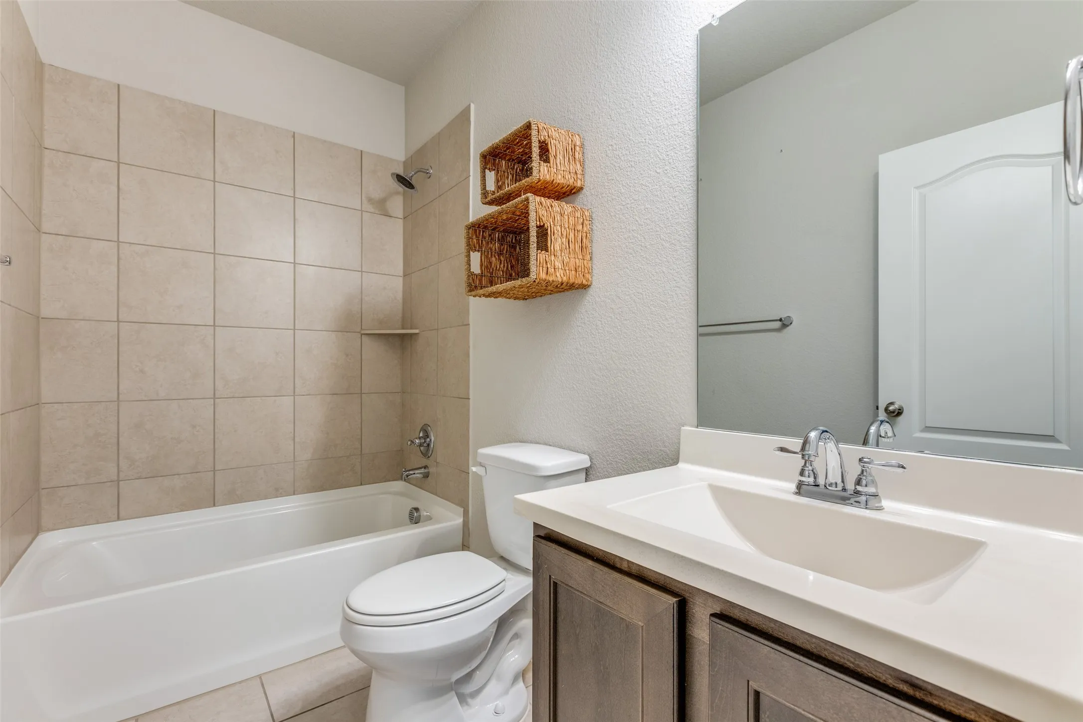 Full bathroom with a tub/shower combination, tiled walls, and a single vanity with an integrated sink