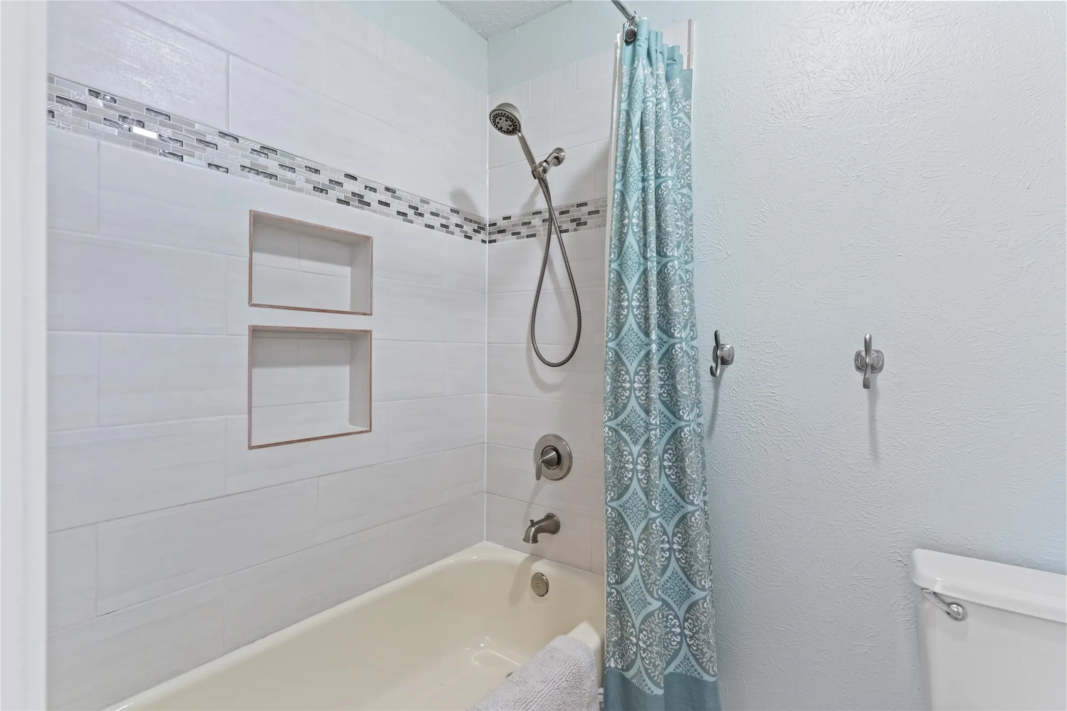 Updated secondary bath with light and bright tile surround