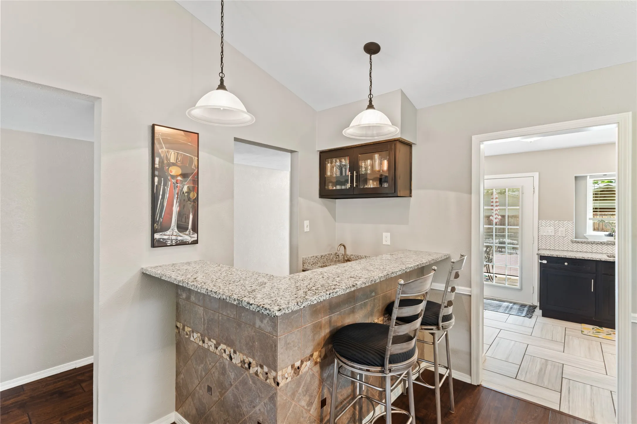 Built-in bar with granit ecountertop, tiled base, and integrated sink.