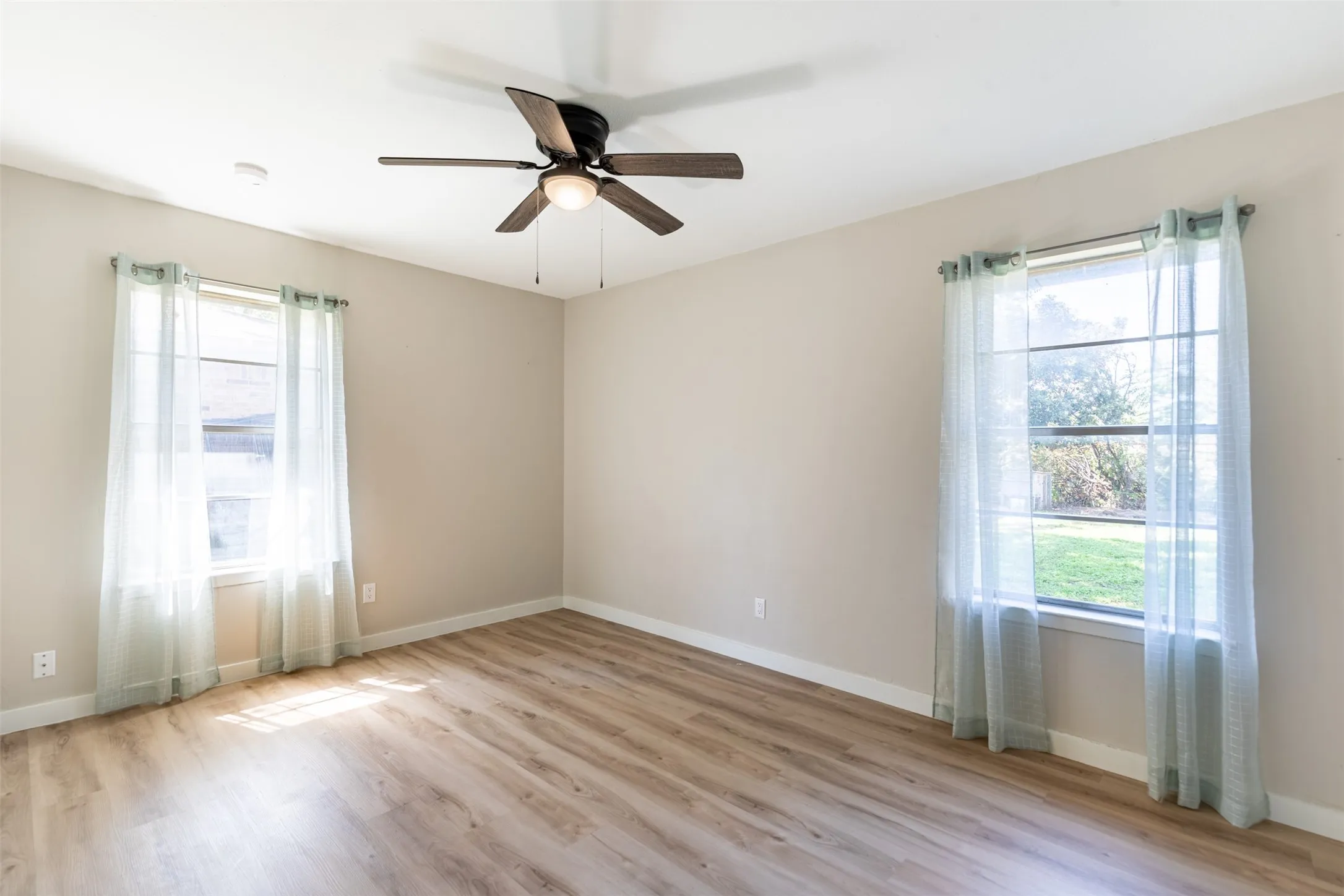 Bedroom with ceiling fan and natural light.