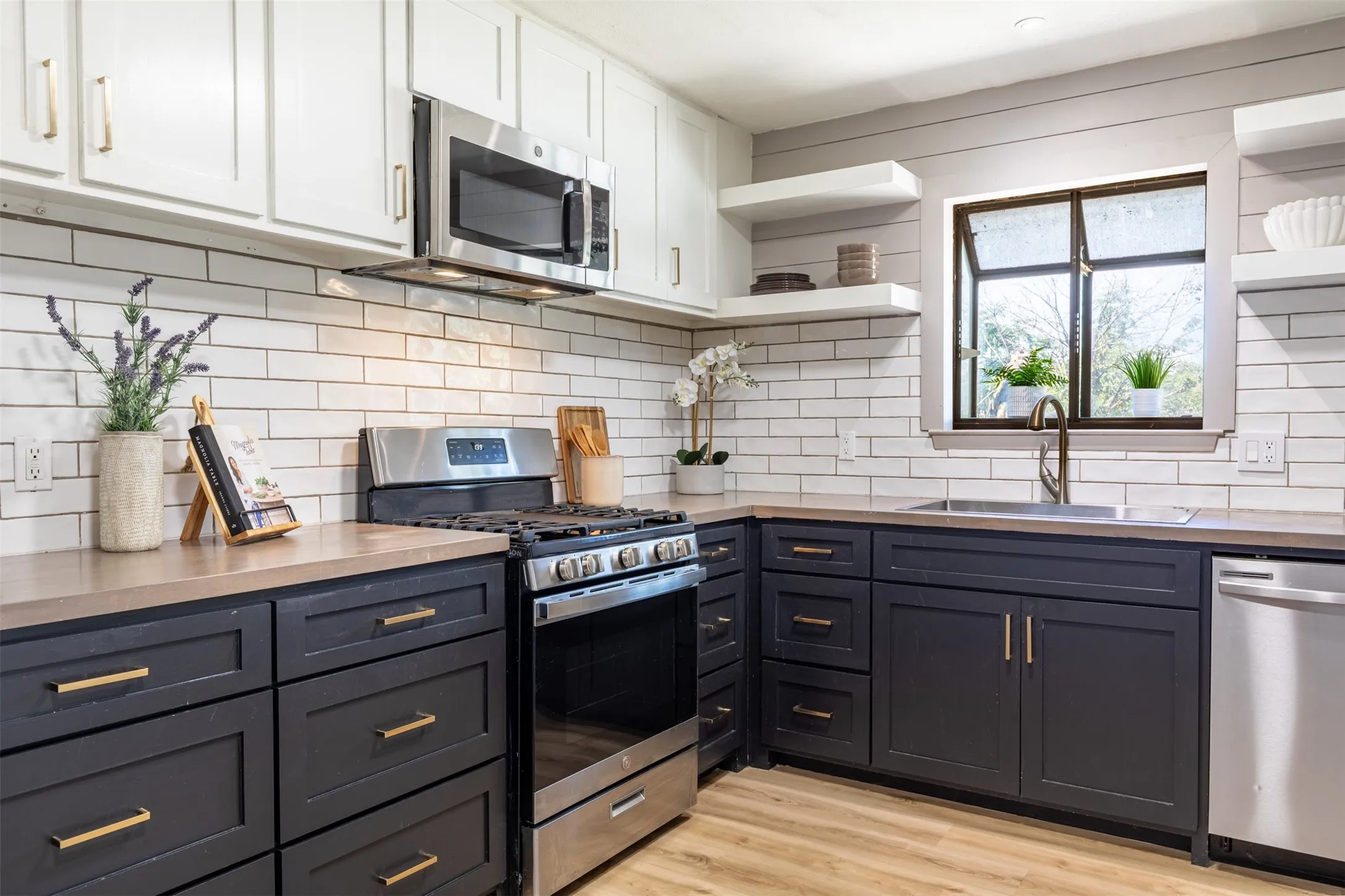 Kitchen with gas range, and window with natural light.