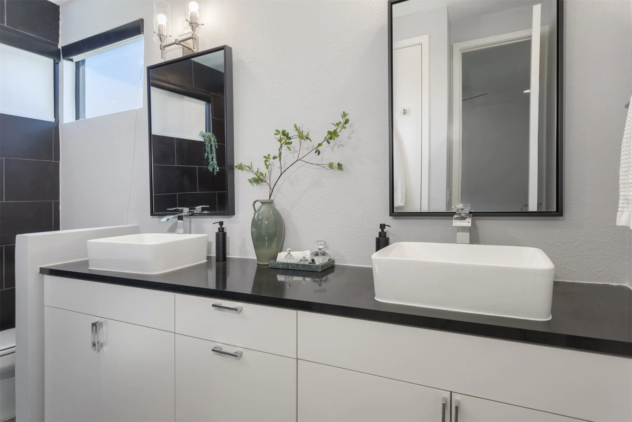 Bathroom featuring a textured wall and double vanity