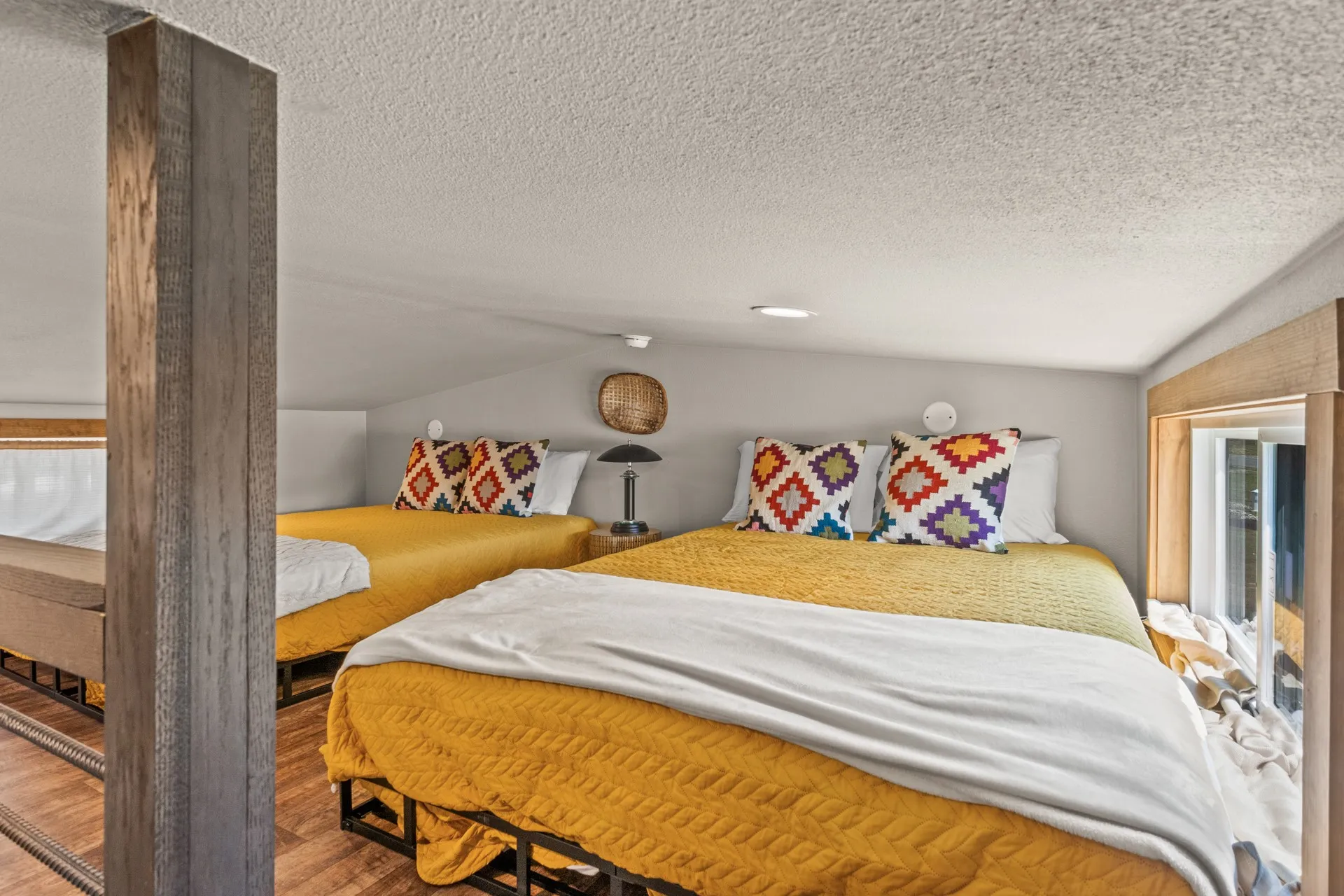 Bedroom featuring vaulted ceiling, a textured ceiling, and wood finished floors