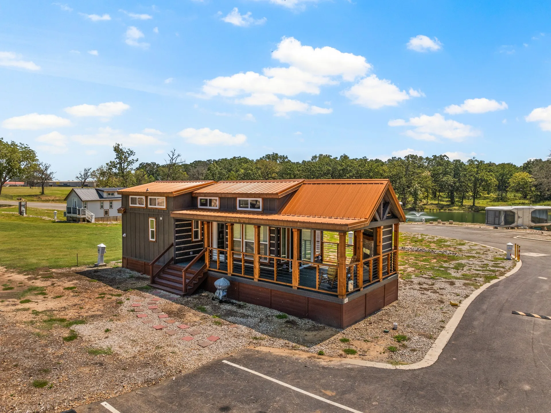 Back of property with covered porch, uncovered parking, and a metal roof