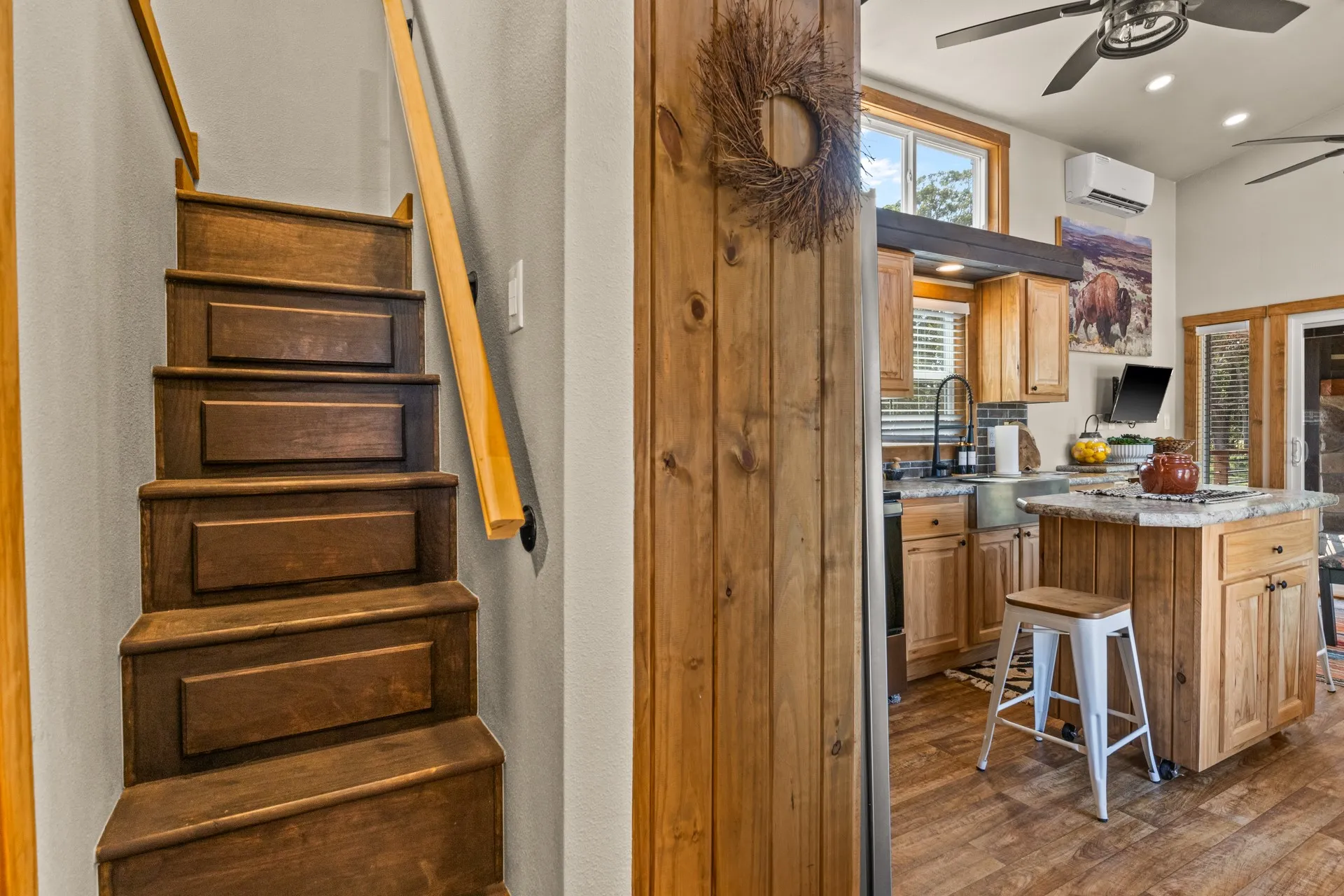 Kitchen featuring ceiling fan, dark wood-style flooring, recessed lighting, a center island, and a kitchen bar