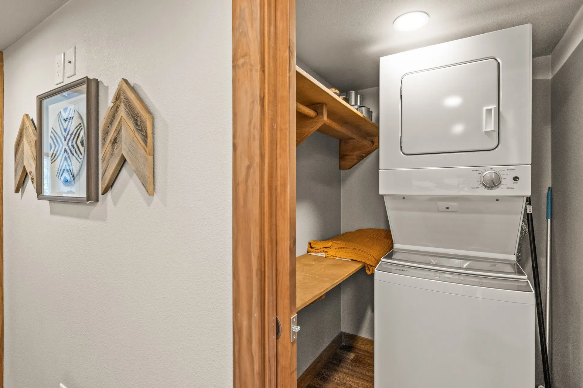 Washroom featuring stacked washer and clothes dryer and dark wood-style floors