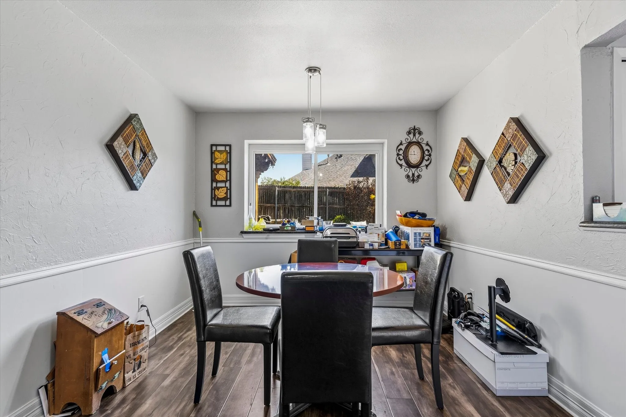 Wood-finish flooring with white baseboards and chair rail molding