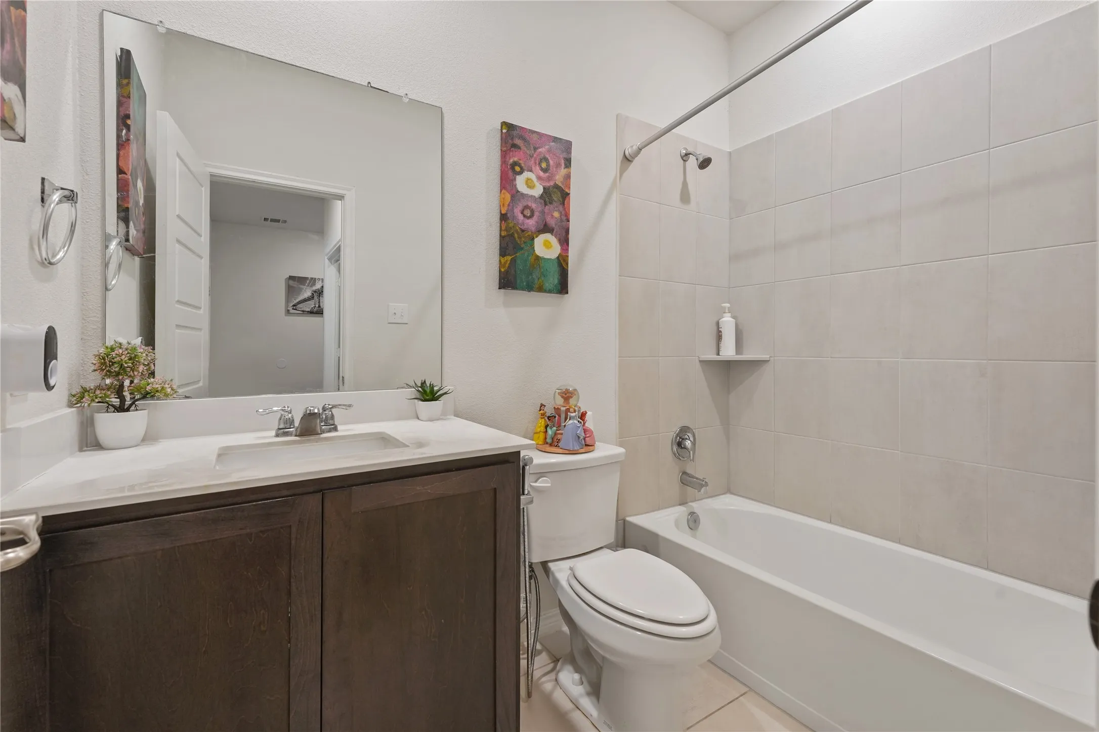 Integrated bathtub and shower with subway tile surround, a built-in shower shelf, and a chrome fixture