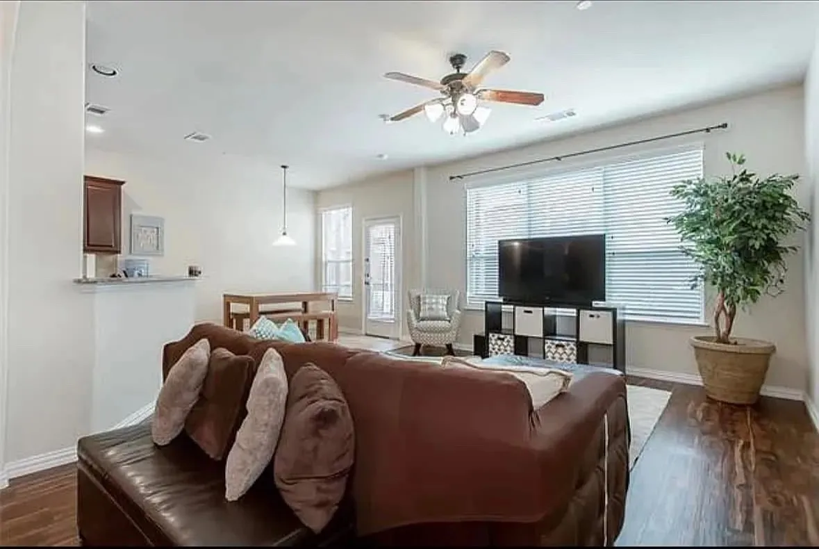Living room with ceiling fan and dark hardwood / wood-style flooring