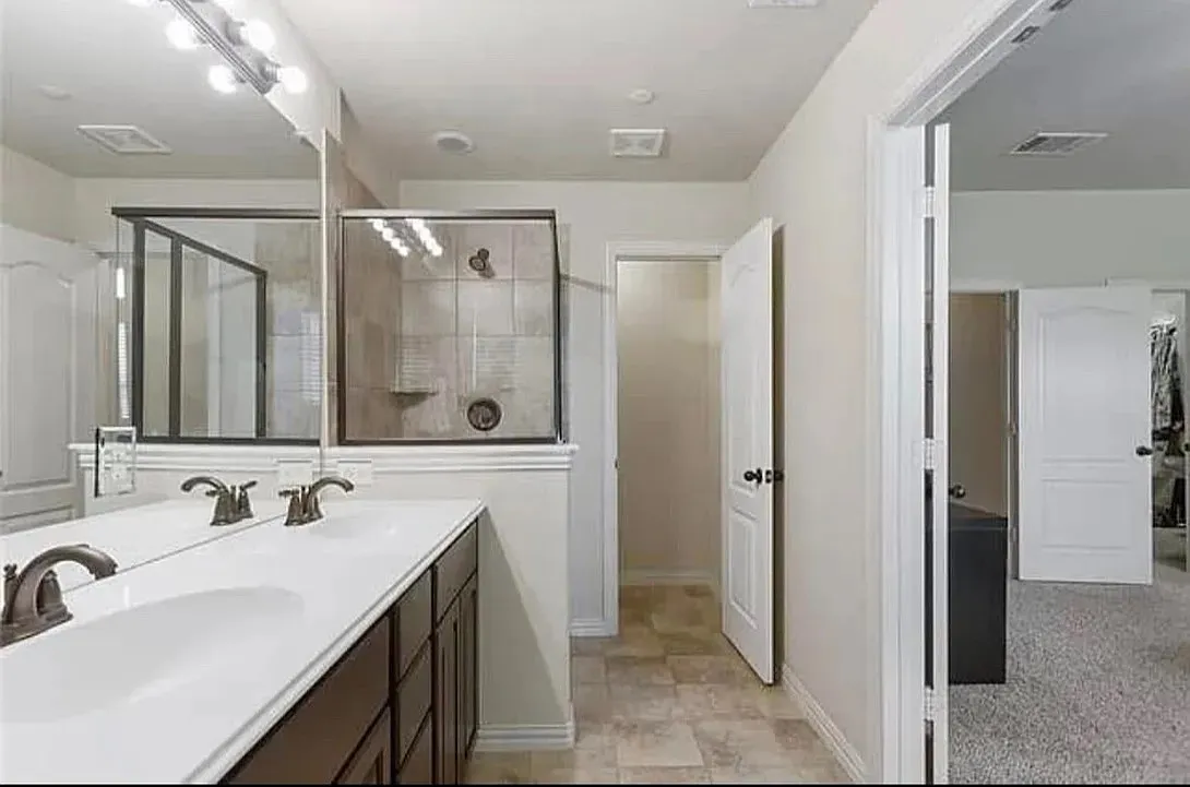 Bathroom featuring a shower with door and vanity