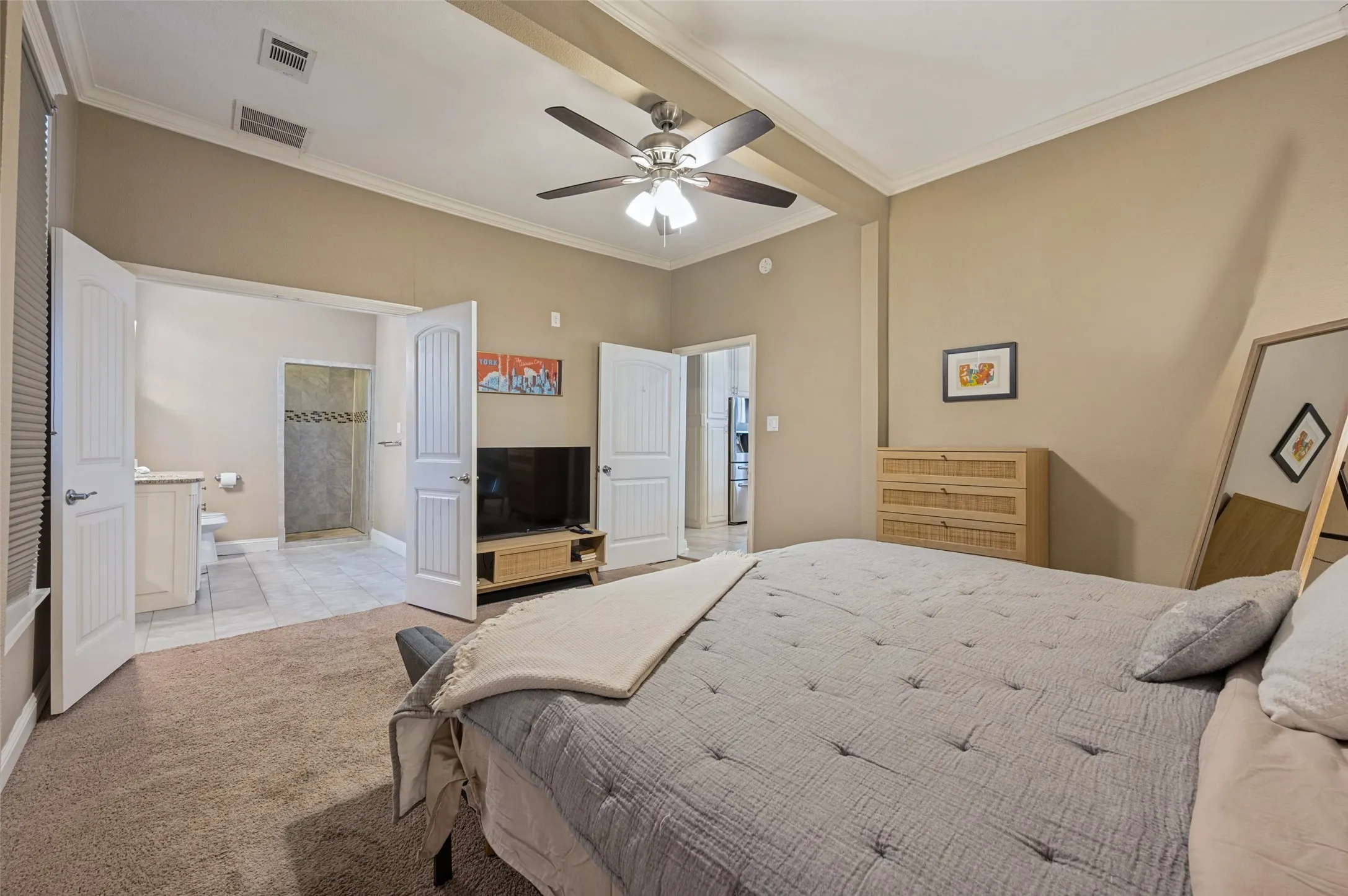 Vaulted ceiling with exposed beams, ceiling fan with integrated lighting, carpeted flooring, and crown molding
