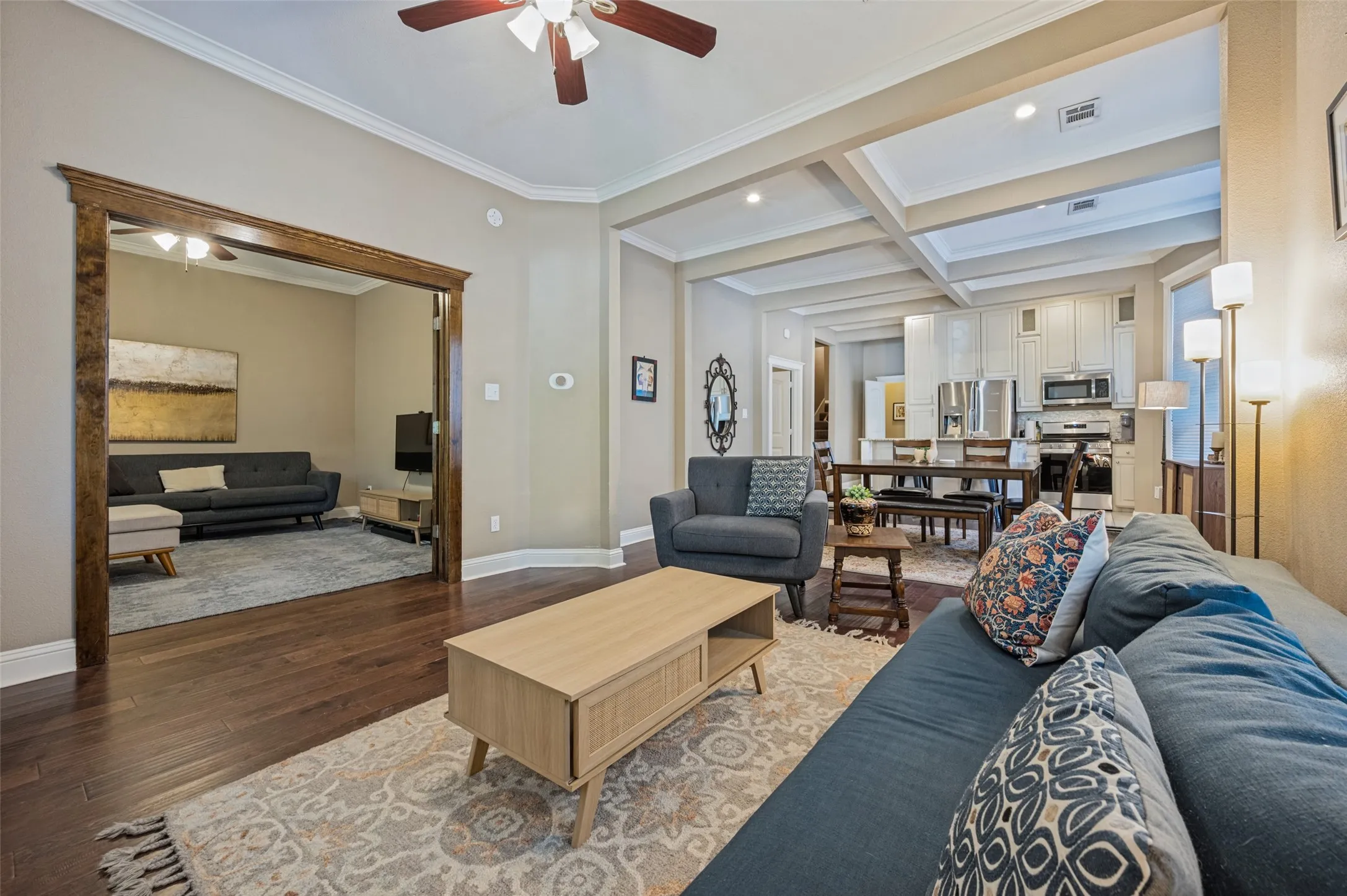 Hardwood flooring throughout, crown molding, coffered ceilings, recessed lighting, and a ceiling fan