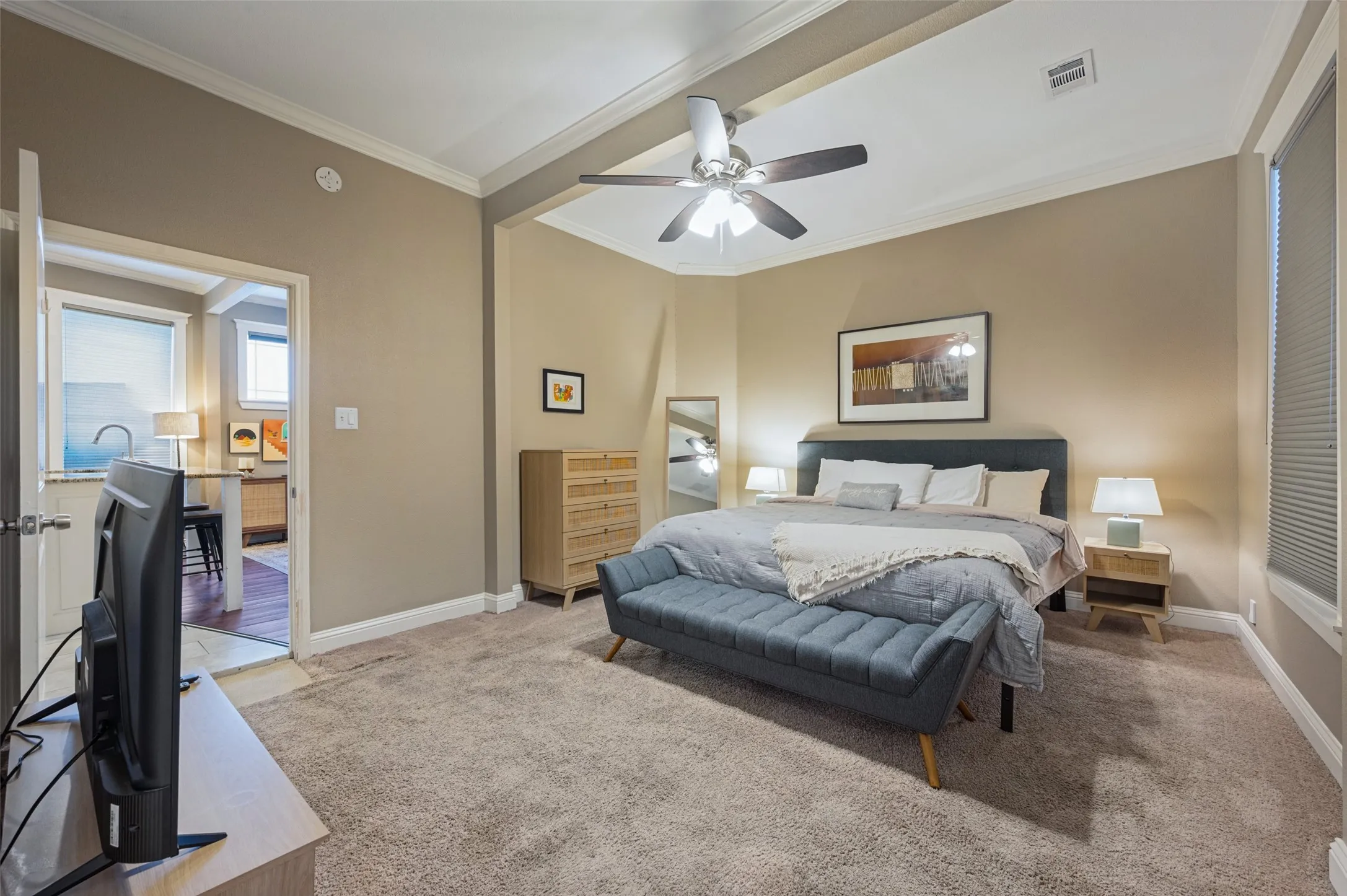 Recessed ceiling with crown molding, ceiling fan, and carpeted flooring