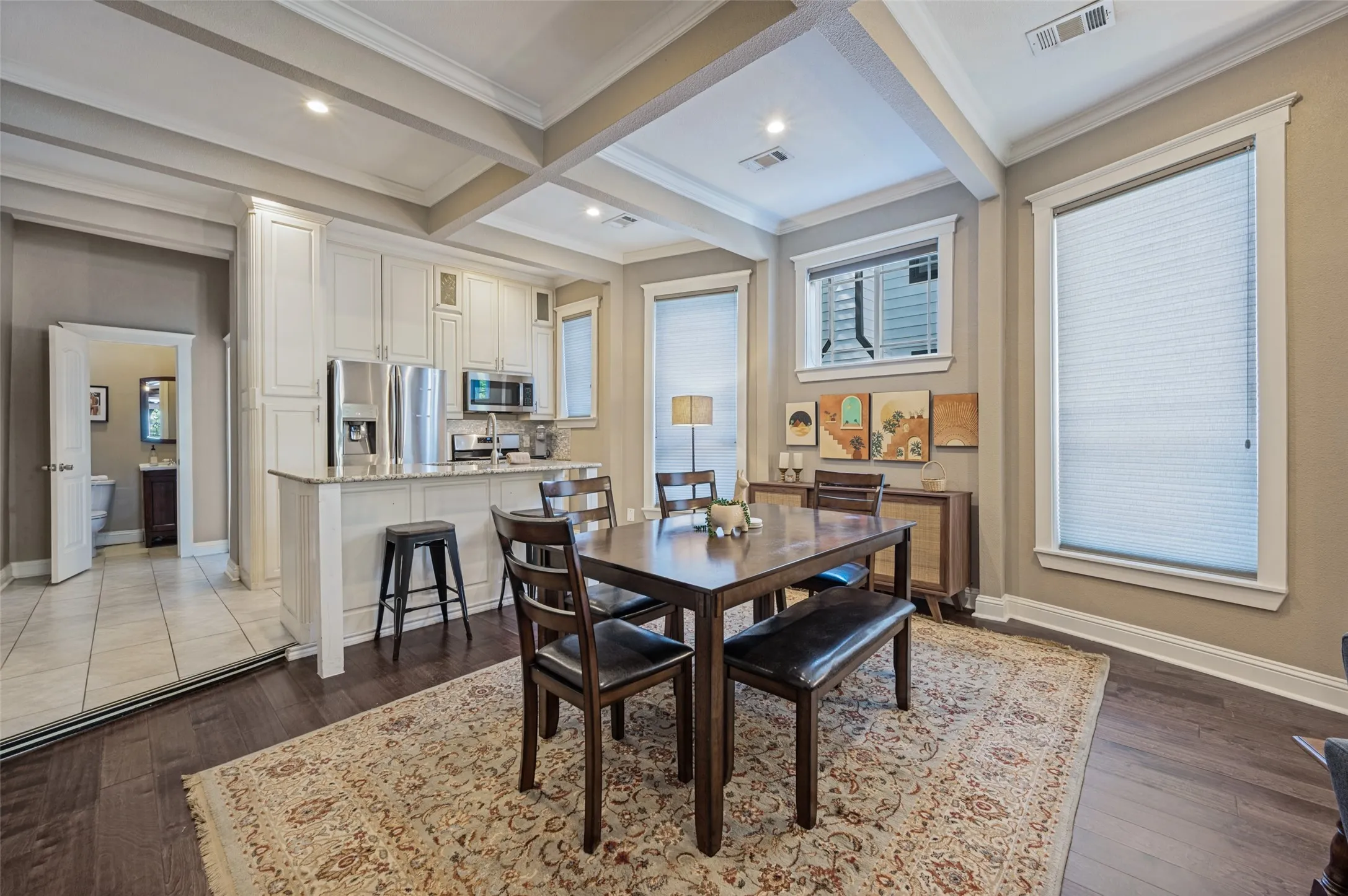 Open-concept living area with dark wood-finish flooring, recessed lighting, and a coffered ceiling